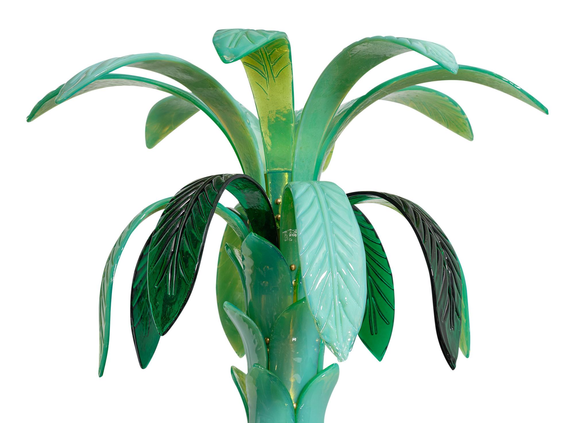Murano glass palm tree floor lamp featuring palm leaves and glass components forming the trunk of various shades of green ranging from emerald to “anice” green. This striking piece brings a lot of impact to any space. It has a single source of light