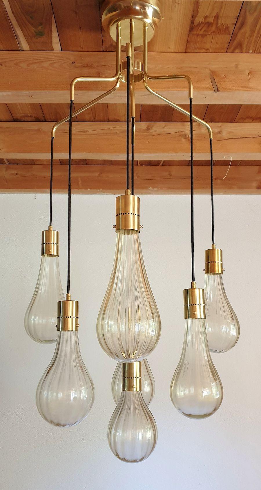 Very unusual and elegant mid century modern Italian pendant chandelier, in the manner of Mazzega, Murano, circa 1970s.
The large vintage Murano pendant light is made of seven hand blown clear with real gold flakes Murano glass drops, each nesting a