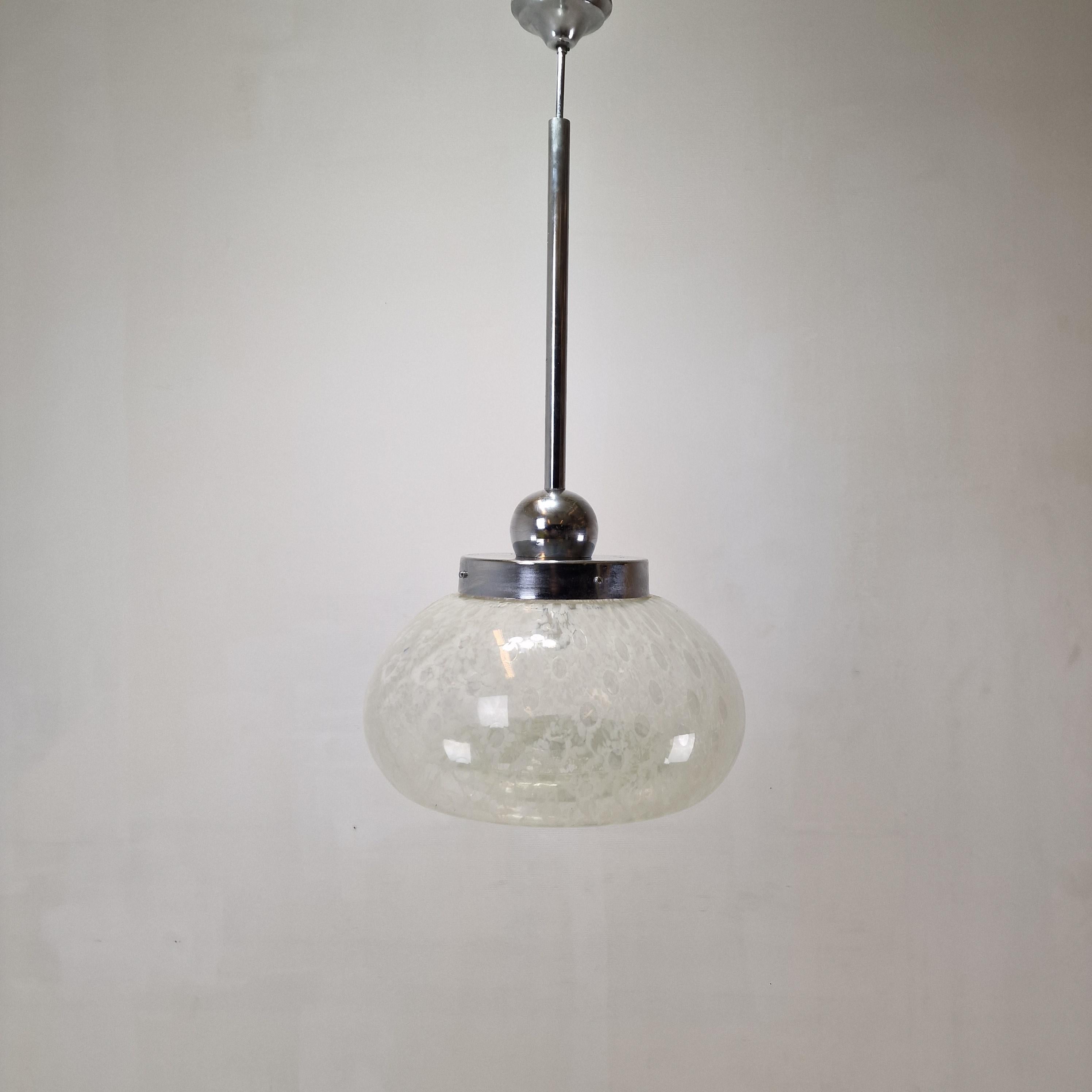 Stunning and rare Italian pendant produced in the 1970s.
Beautiful and very large hand blown Murano glass bulb in transparent glass with very nice white accents.

Due to the texture of the shade the lamp gives a very calm and pleasant light. 
In the