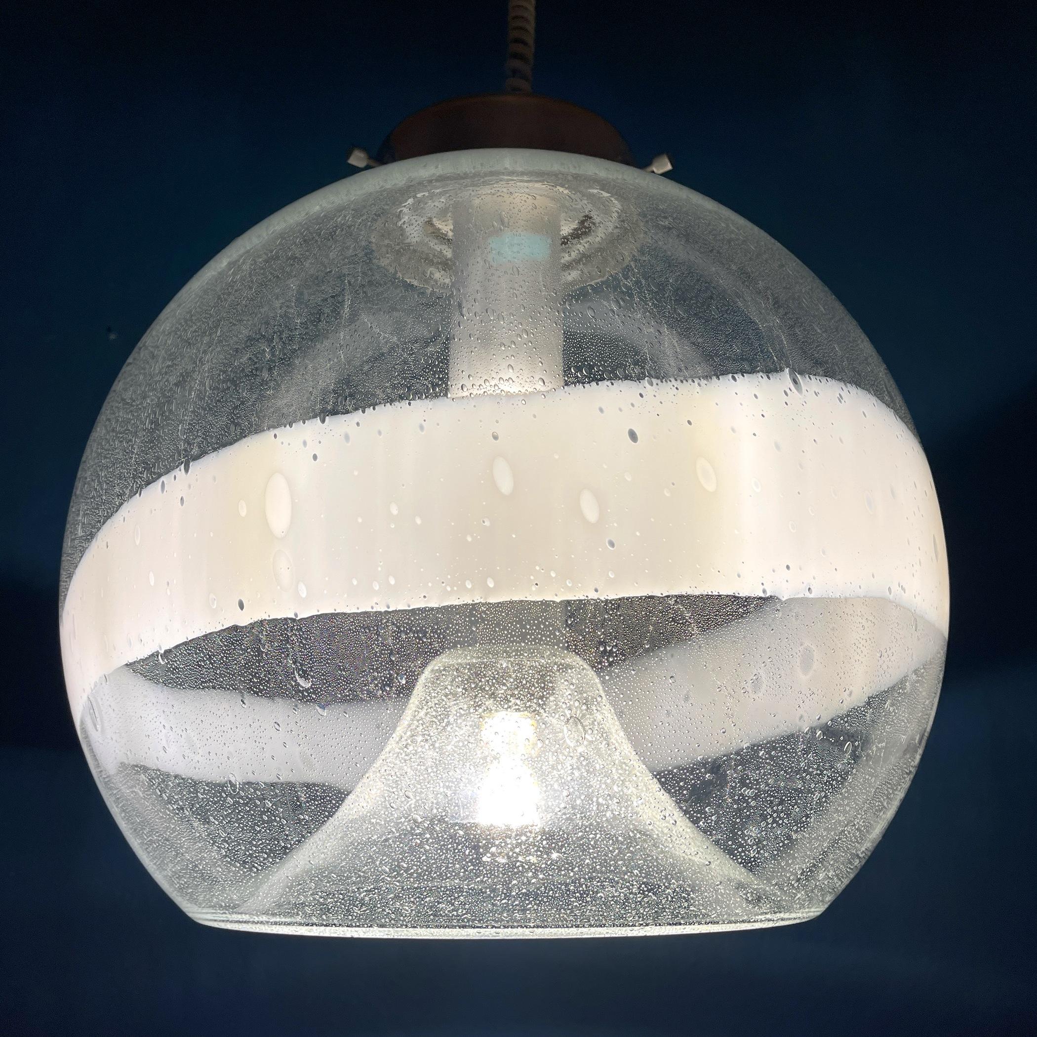 Die seltene große Pendelleuchte aus mundgeblasenem Murano-Glas, entworfen von Ettore Fantasia und Gino Poli für Sotis Murano, Italien, 60er Jahre.
Ein transparenter Glasschirm mit einer 