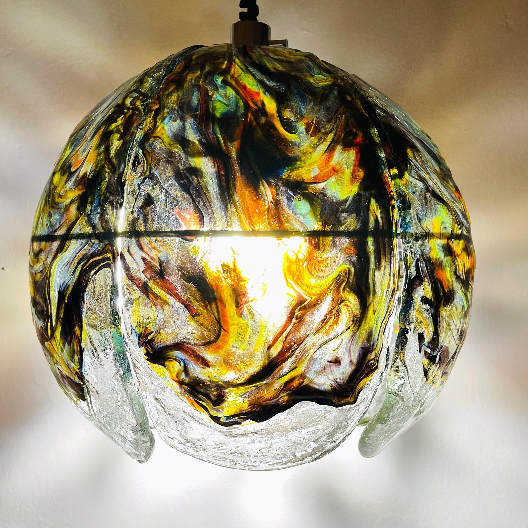 Élevez votre espace de vie avec cet extraordinaire lustre en verre de Murano, unique en son genre, fabriqué par les célèbres artisans italiens de Mazzega dans les années 1970. Irradiant d'élégance et de sophistication, cette pièce à couper le
