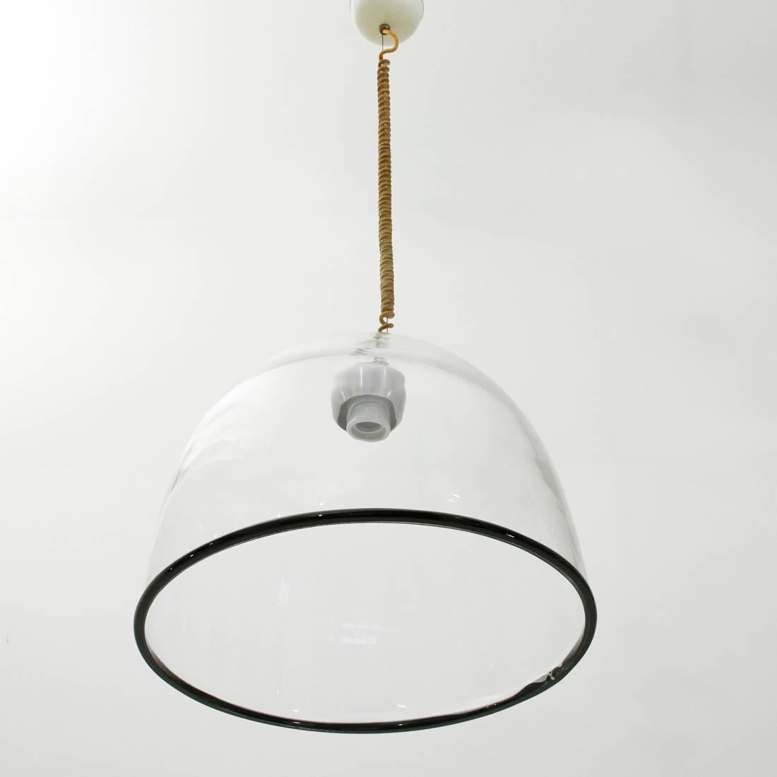 Chandelier produced at the end of the 1960s by Leucos on a project by Renato Toso.
Diffuser in transparent Murano glass, thick, with black border.
Possibility to adjust the height of the wire and the inclination of the diffuser.
Good general
