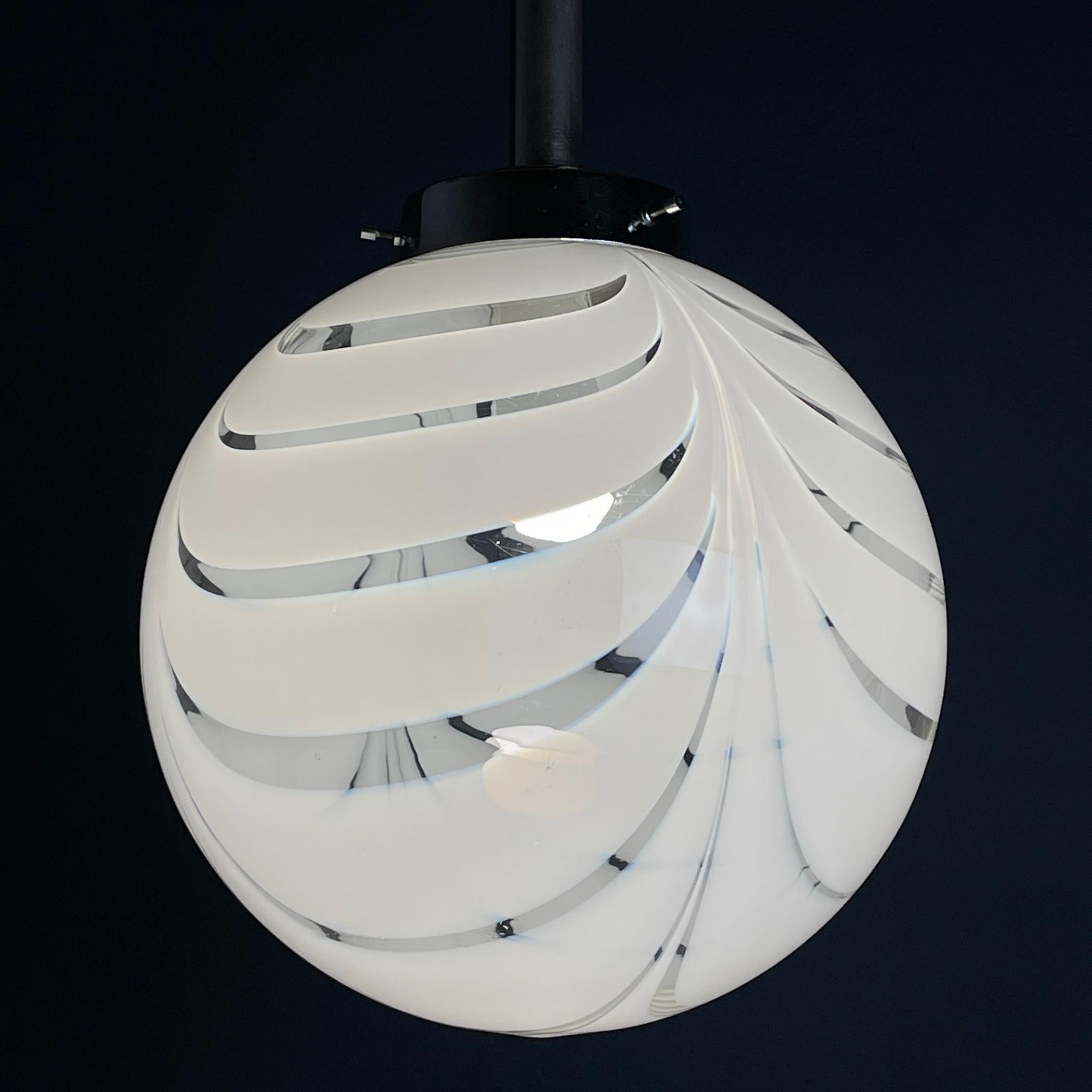 Introduce a touch of elegance to your space with this beautiful Murano glass lamp, crafted in Italy during the 1960s. Radiating soft and soothing light when illuminated, it effortlessly brightens the room with its captivating glow. In great working