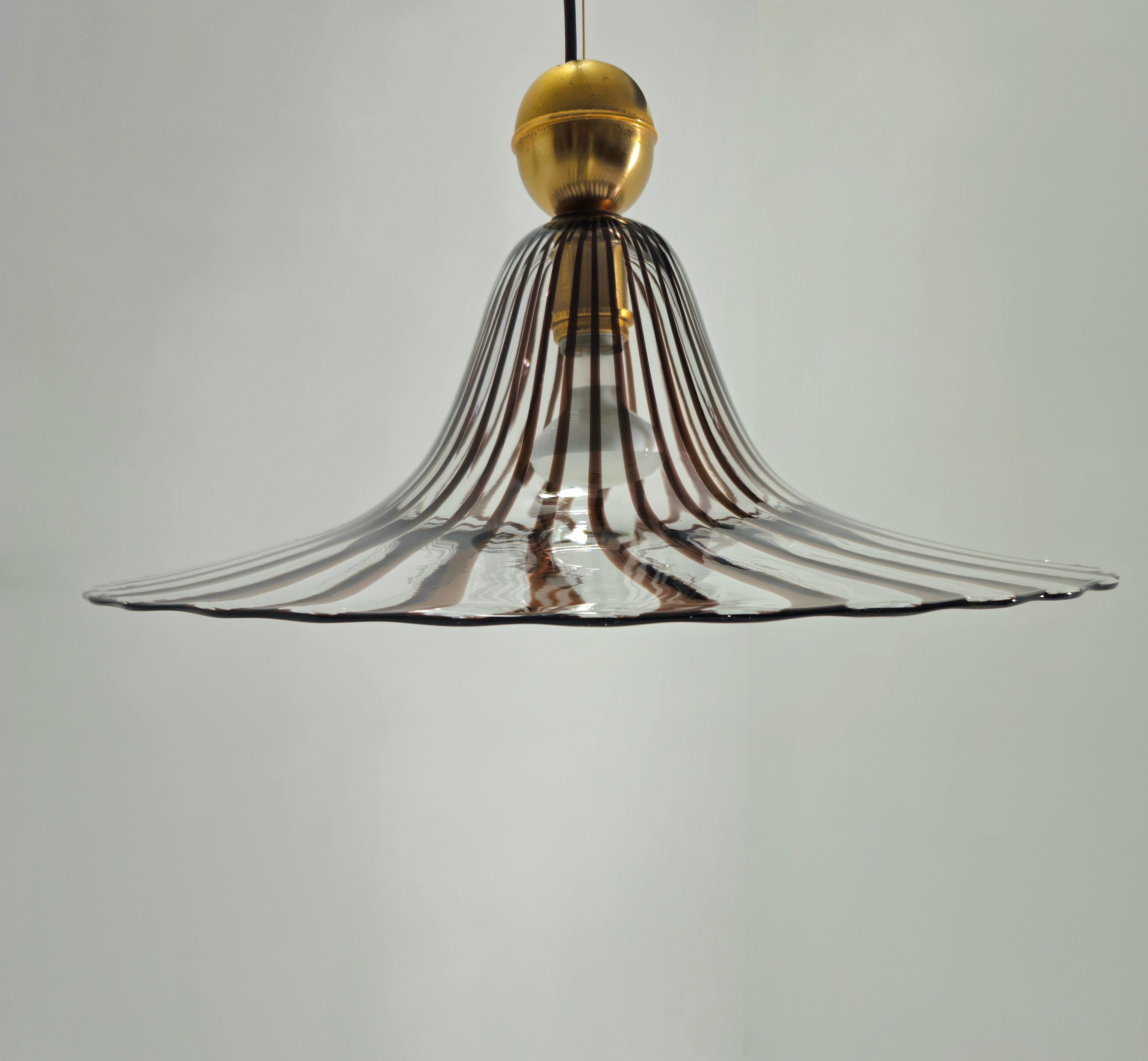 Production Venini, Italy ca. 1970. Pendant lamp with colorless glass diffuser decorated with sepia-colored canes. One light. Rare piece. Behind its simplicity is a highly appreciated lighting that gives charm to the environment that hosts it. 