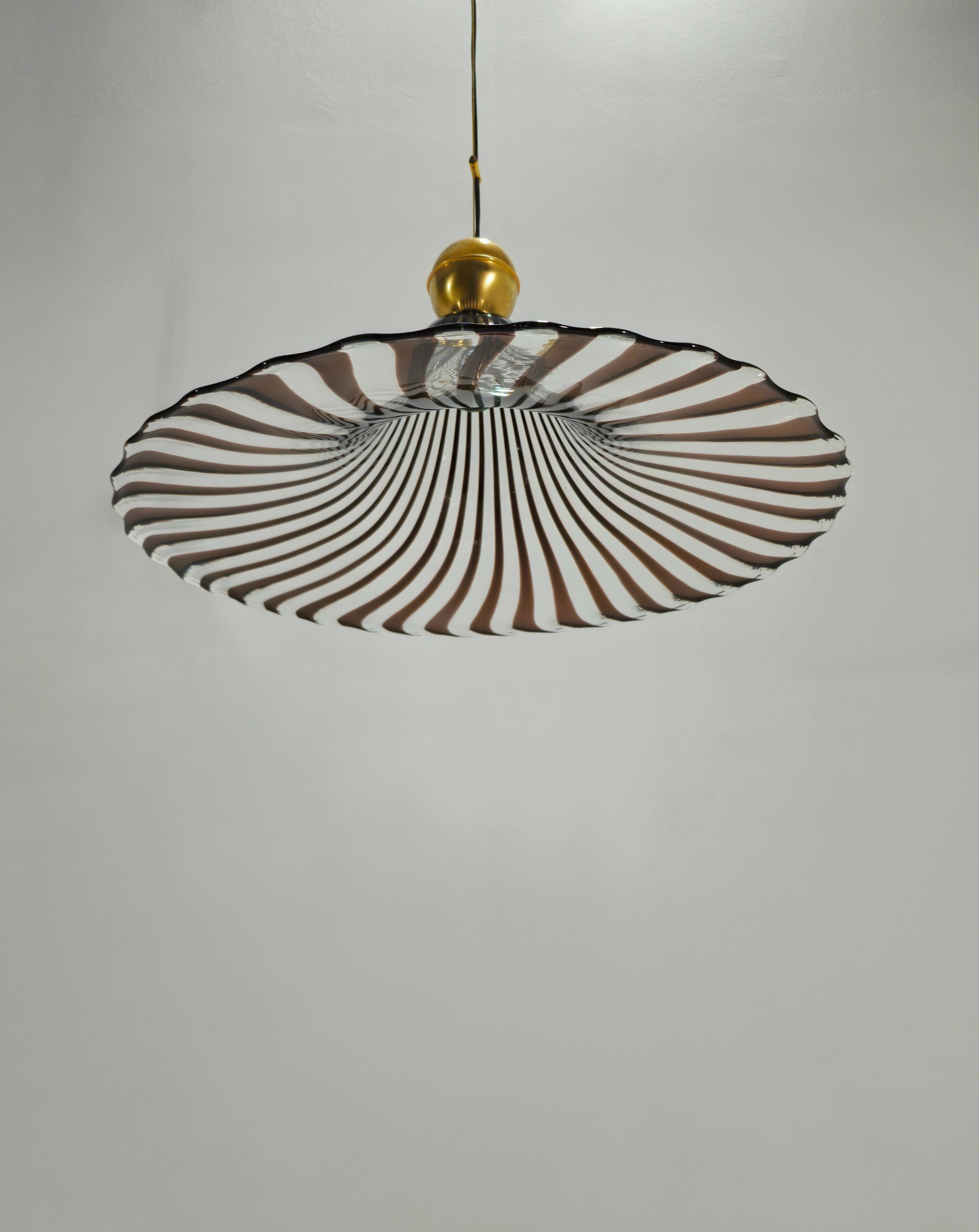 Production Venini, Italy ca. 1970. Pendant lamp with colorless glass diffuser decorated with sepia-colored canes. One light. Rare piece. Behind its simplicity is a highly appreciated lighting that gives charm to the environment that hosts it. 