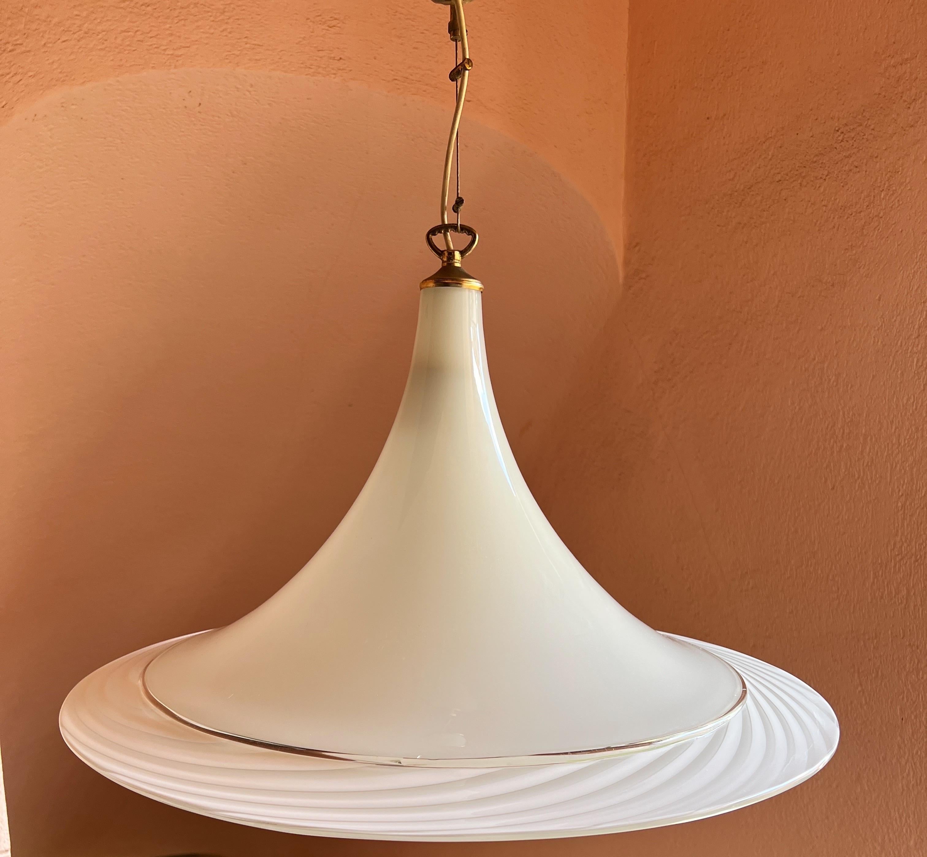 Lampada a sospensione in vetro di Murano bianco e trasparente soffiato a mano. Se lo desideri, il paralume può essere dotato di una catena più lunga. 