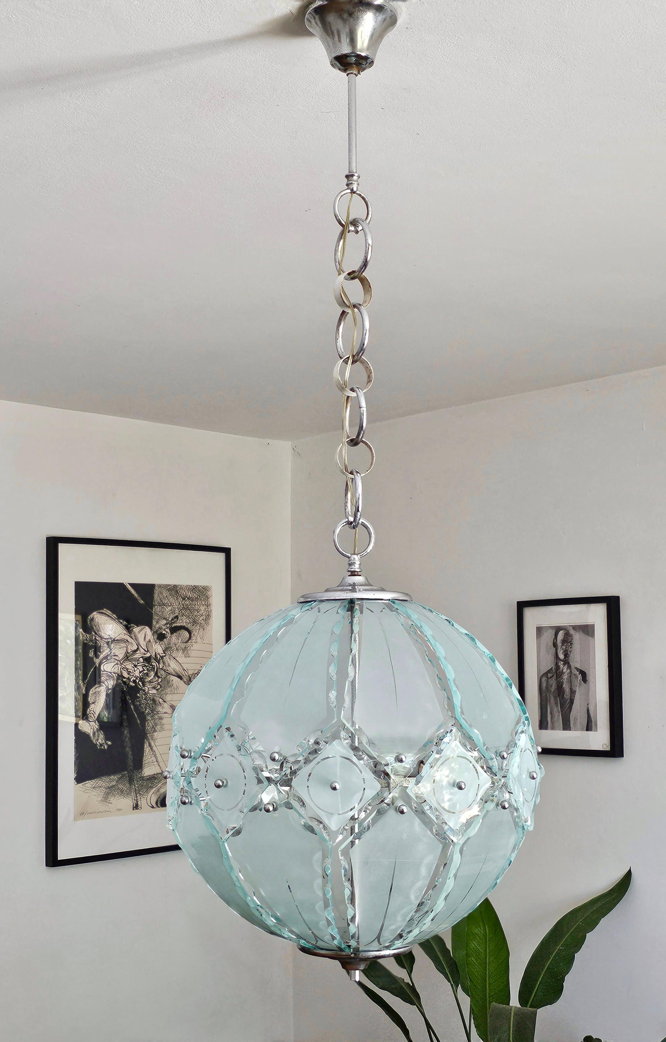In this listing you will find one of the most spectacular pendant lights of the 70s, designed in collaboration between Zero Quattro and Fontana Arte. It features spheric shape consisting of pieces of glass with rough edges. It has 5 light bulb