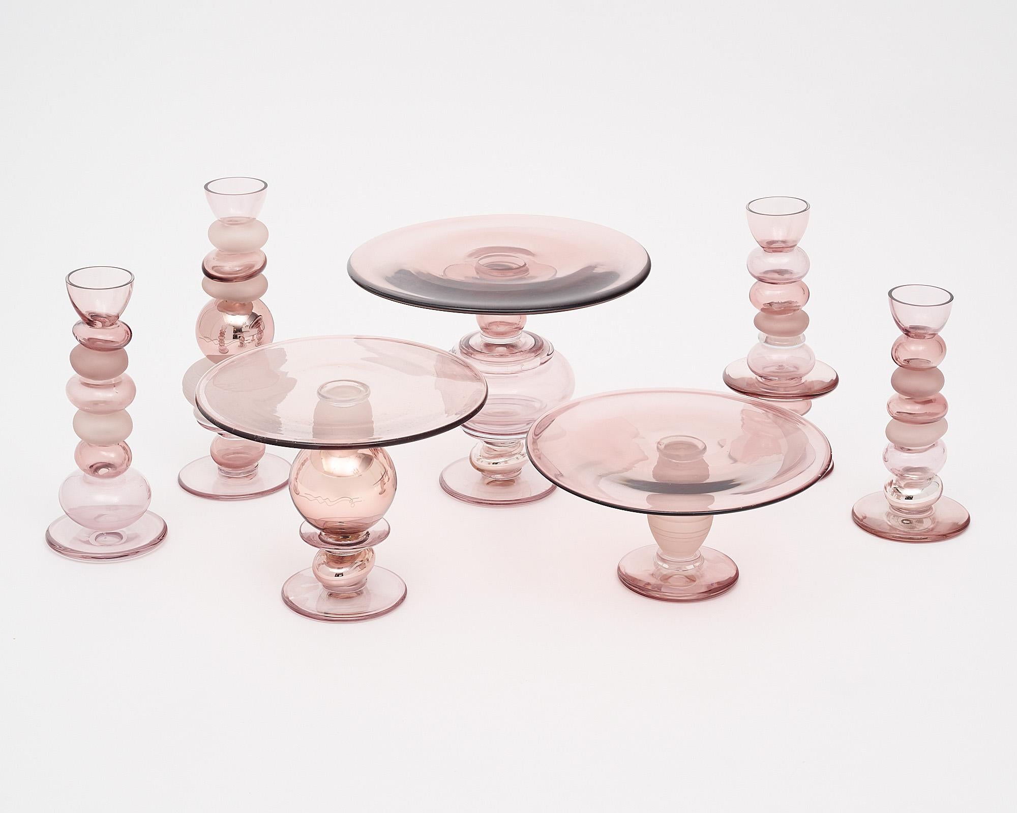 Set of three cake stands and four candle sticks made of hand-blown Murano glass. This group is made in a beautiful dusty rose pink tone, and includes alternating finishes, which glass elements in transparent glass, frosted glass, and mirrored glass.
