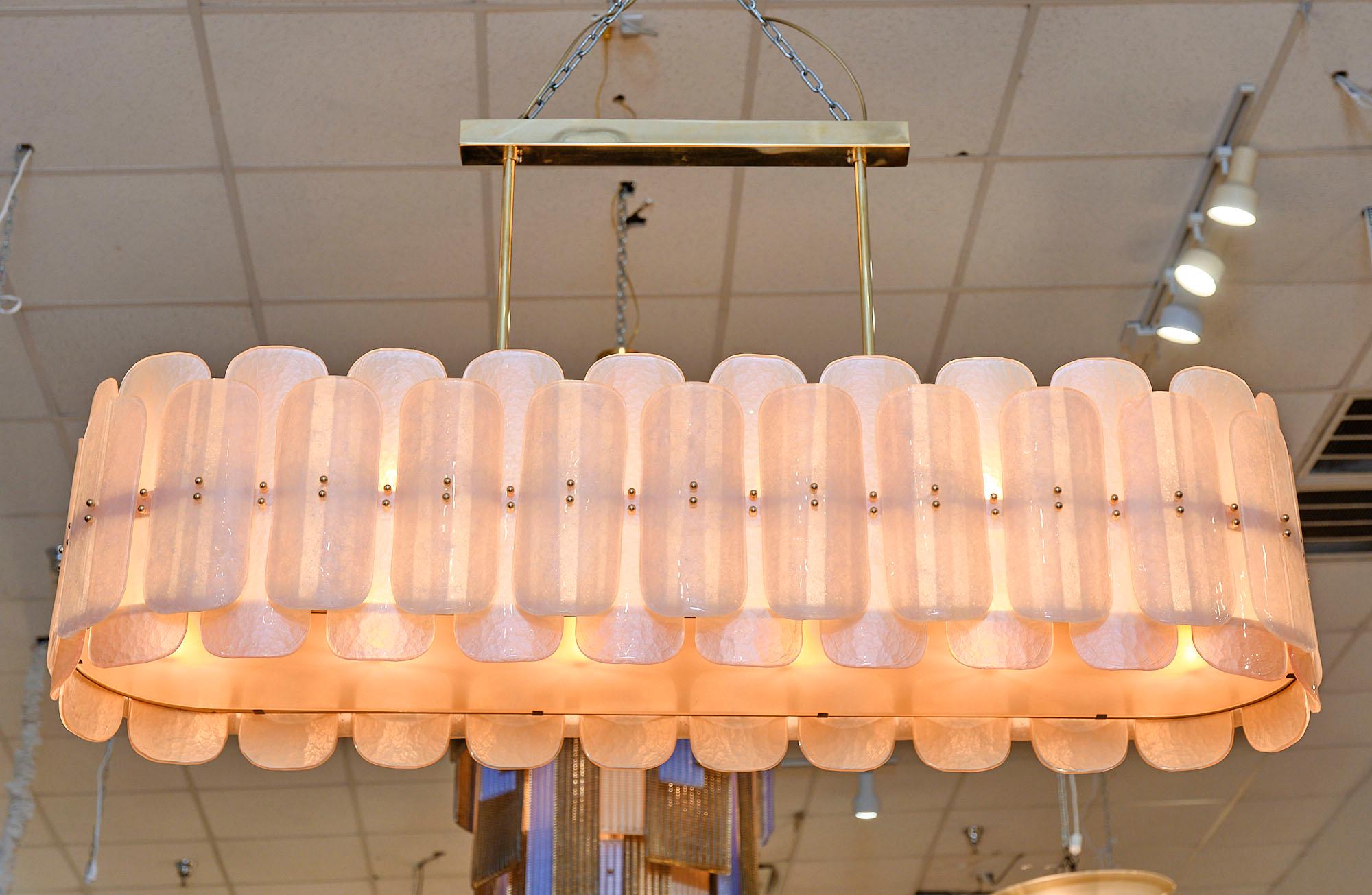 Chandelier from the island of Murano featuring a gilt brass structure supporting an array of pink textured glass components. All of the glass is hand-blown in Italy. It has been newly wired to fit US standards.

This fixture is a special order from