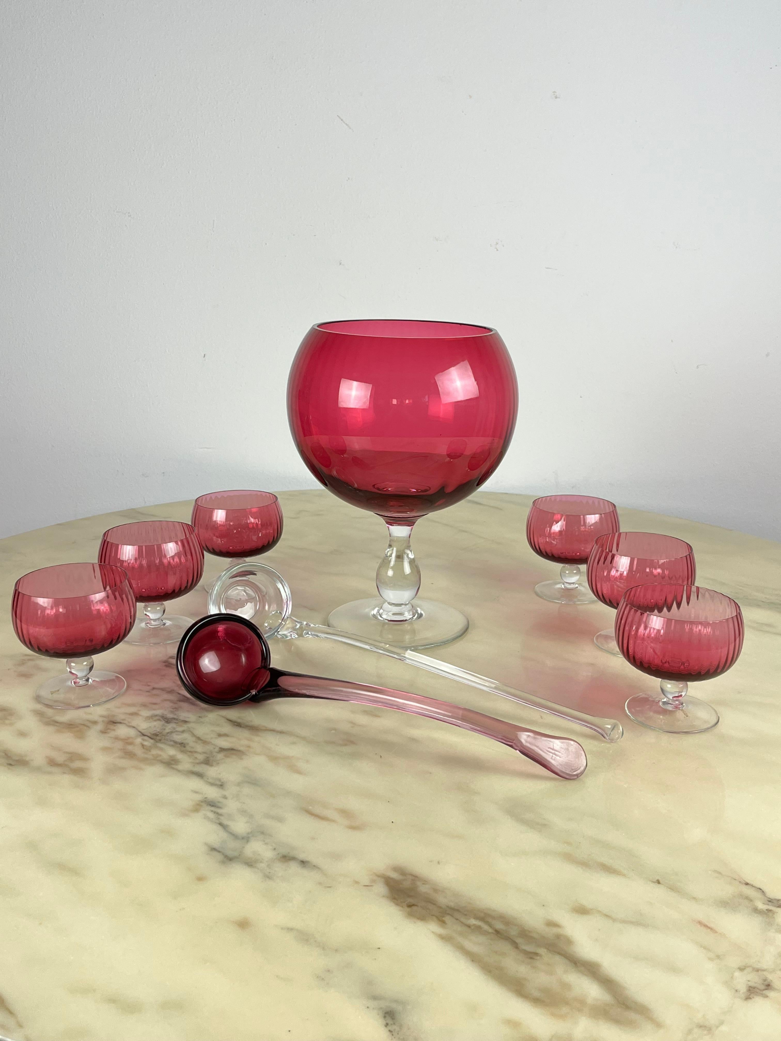 Murano glass punch or sangria set, Italy, 1940s
The set consists of the large cup plus six small ones and two ladles. All blueberry and transparent Murano glass. Only  a small chip in the large cup.
The ladles are 39 cm long, the one made of