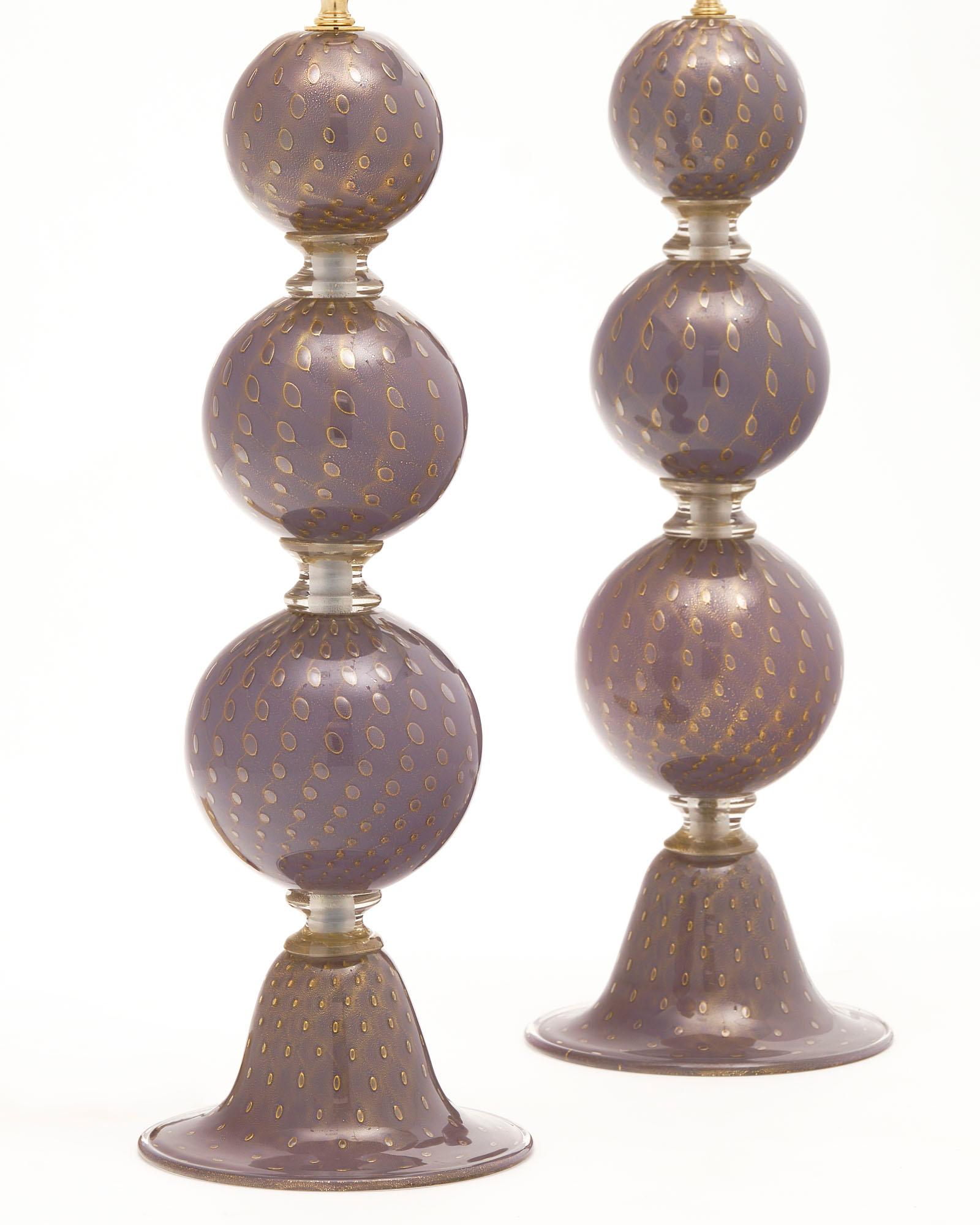 Paire de lampes italiennes de l'île de Murano. Cette paire est en verre soufflé violet. Les sphères empilées sont séparées par des anneaux en verre transparent et reposent sur une base conique. Le verre a été fusionné avec des bulles 