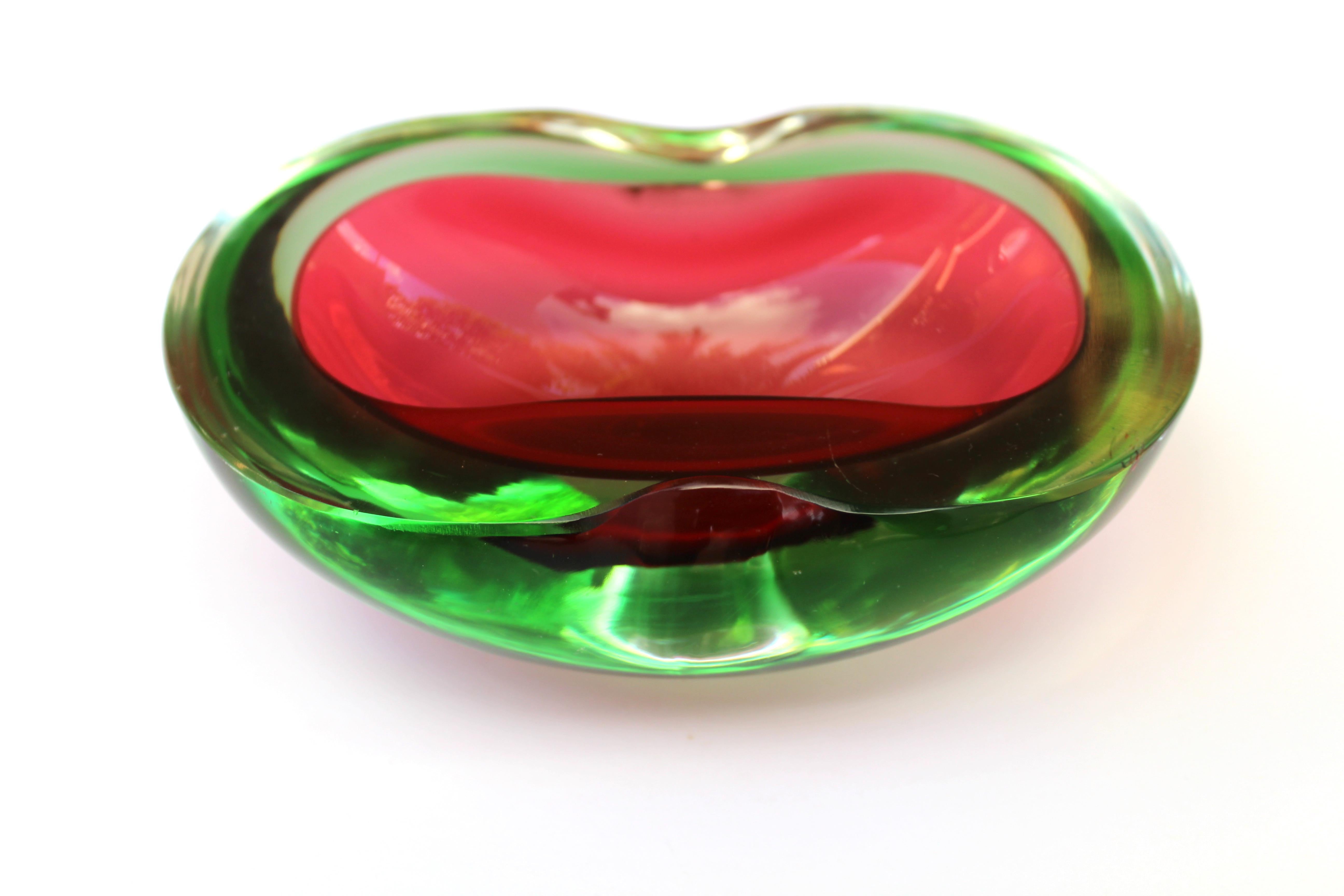 Mid-Century Modern Murano glass bowl / ashtray. Hand blown Sommerso cased glass in hues of vibrant red over green. Bowl has oval freeform with rounded edges and features two indents along the rim. Gorgeous from every angle.