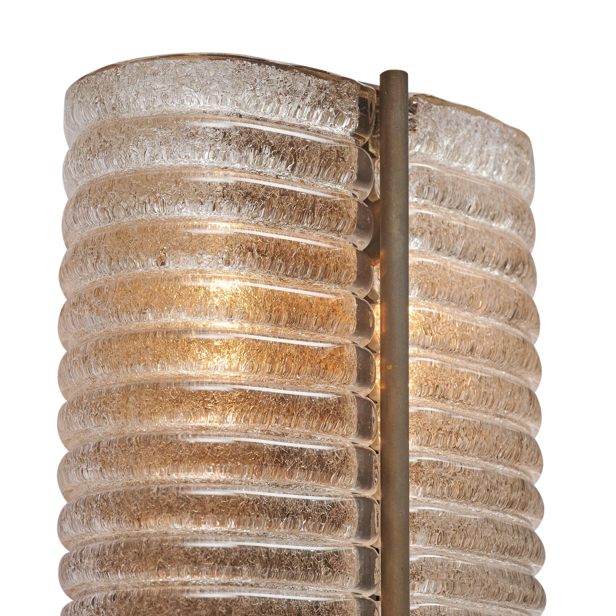 Pair of sconces from Murano, Italy made of hand-blown and stamped glass. The ribbed texture of the glass creates a beautiful filter for the light. The structure is made of brass. The fixtures have been newly wired for US standards.

This set is a