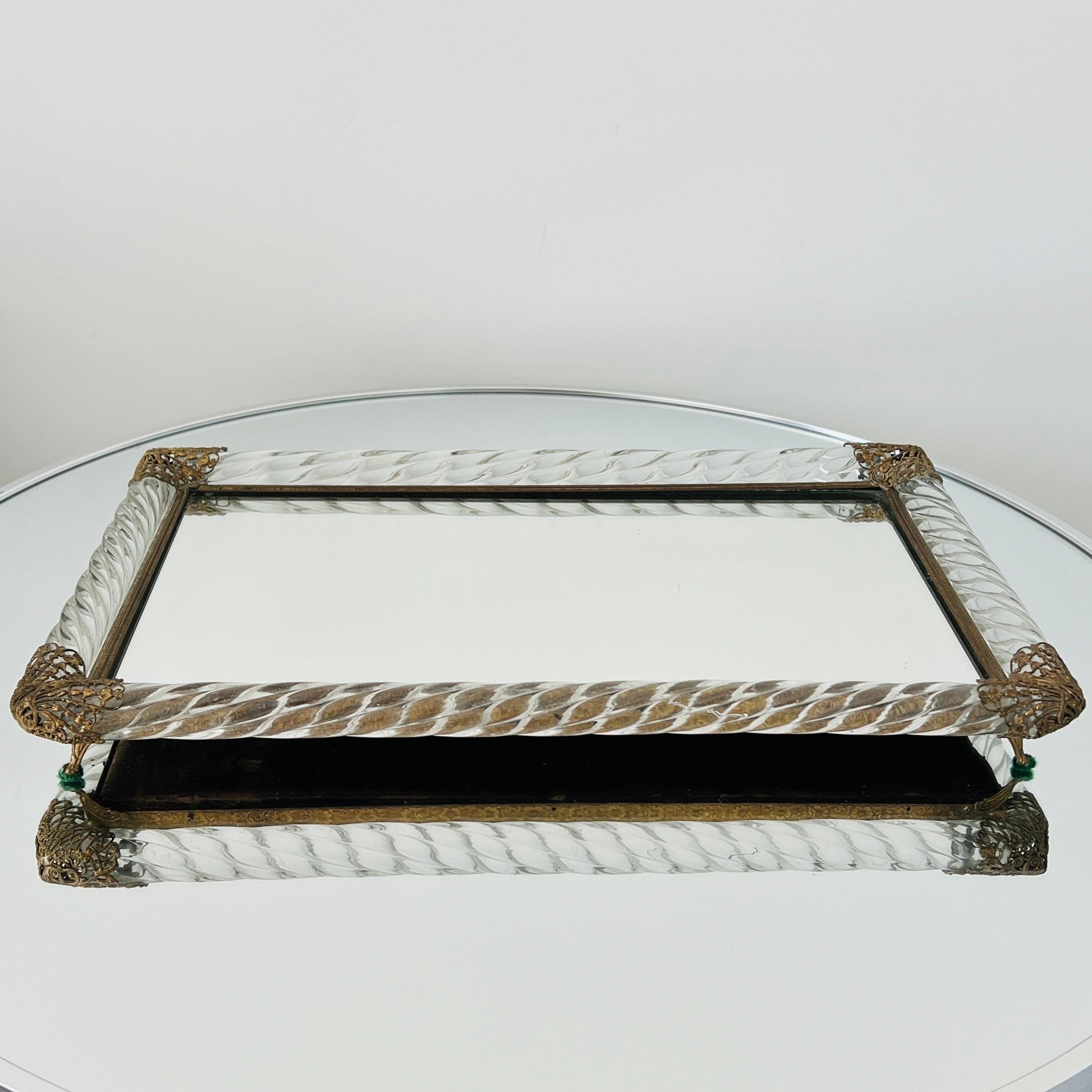 Mid-Century Modern mirrored vanity tray with thick Murano glass rope frame.  The tray features beautiful gold metal filigree accents in the form of butterflies. Unique design also features stylized feet which allows the tray to stand above the