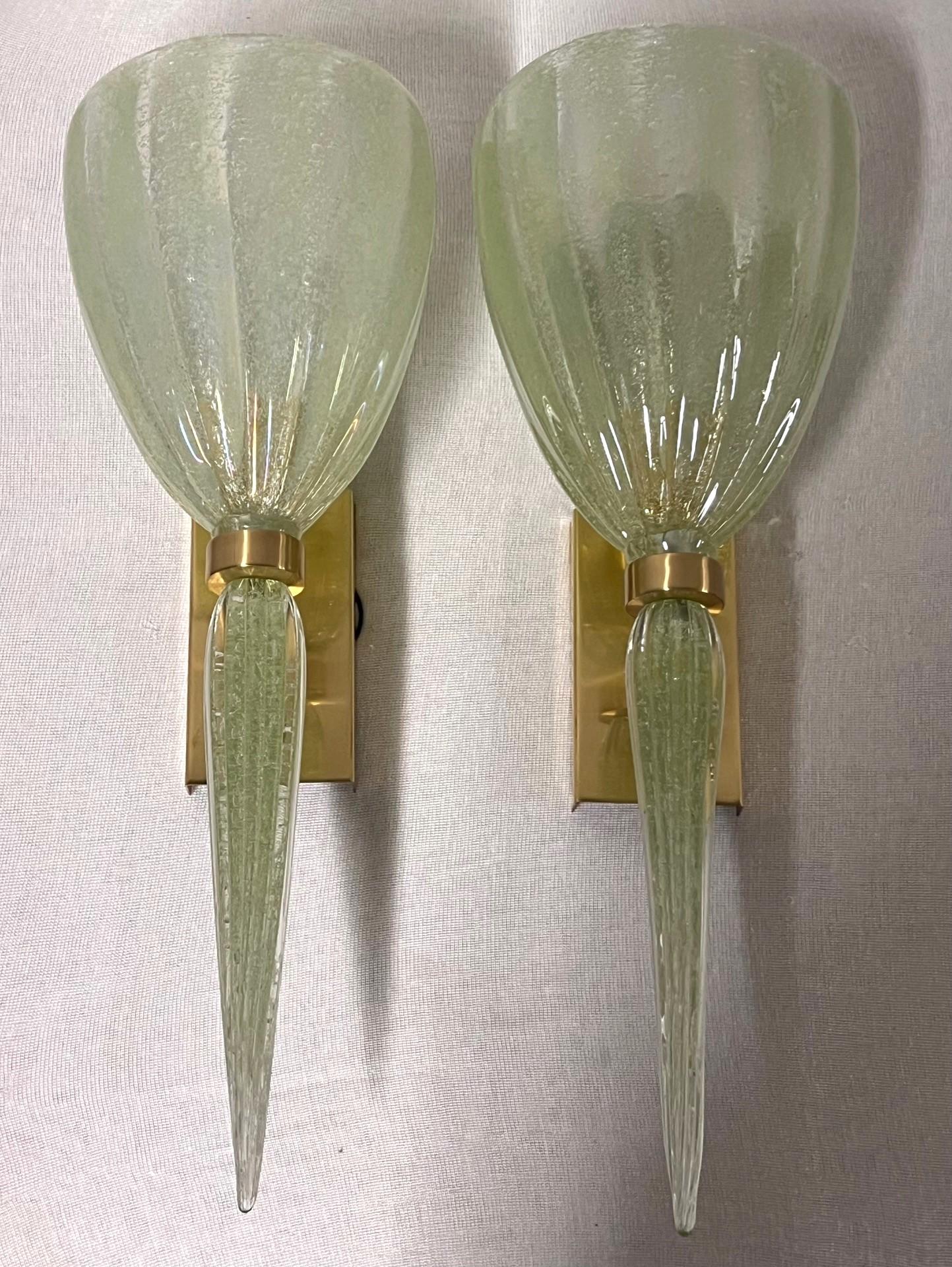 Grande applique in vetro di Murano soffiato a mano dal maestro vetraio Alberto Dona

Il vetro strutturato verde chiaro e gli accenti in ottone creano un ambiente caldo e invitante. 