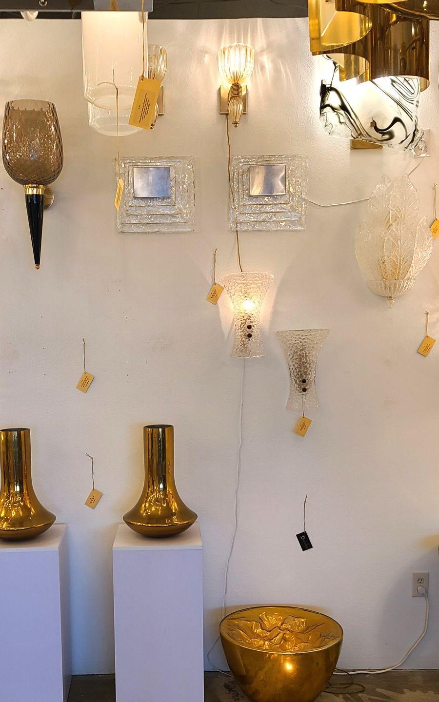 Pair of large square clear glass Mid Century Modern wall sconces, by Mazzega, Italy 1970s.
The vintage sconces are made of four square clear Murano glasses and a nickel one, nesting the two light bulbs.
The Murano sconces are professionally rewired