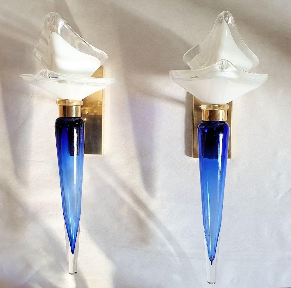 Paire d'appliques en verre de Murano bleu et blanc, par Seguso Italie 1970
Les appliques néoclassiques sont faites d'un verre blanc de Murano, nichant l'ampoule, en forme de fleur organique ;
et un fleuron en verre de Murano graduellement bleu à