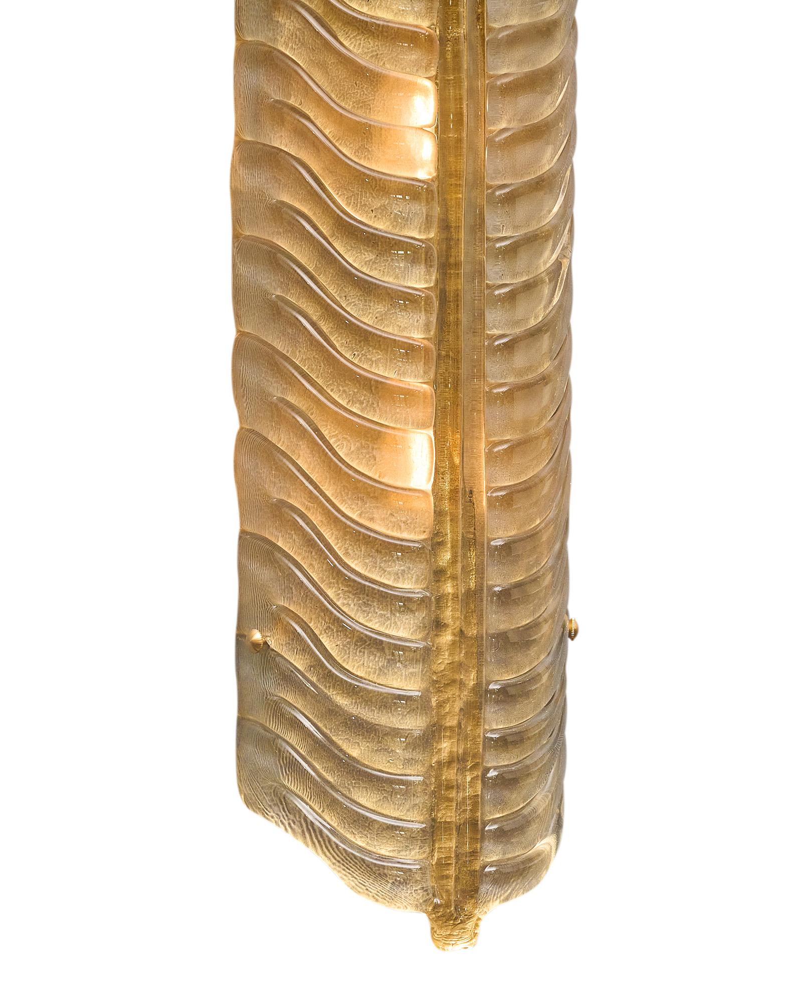 Ein Paar Wandleuchter aus mundgeblasenem Murano-Glas mit blattähnlichem Muster und Form. Jede Leuchte ist aus Rauchglas gefertigt und weist in der Mitte einen goldenen Glasrücken auf. Sie wurden neu verkabelt, um den US-Normen zu entsprechen.
