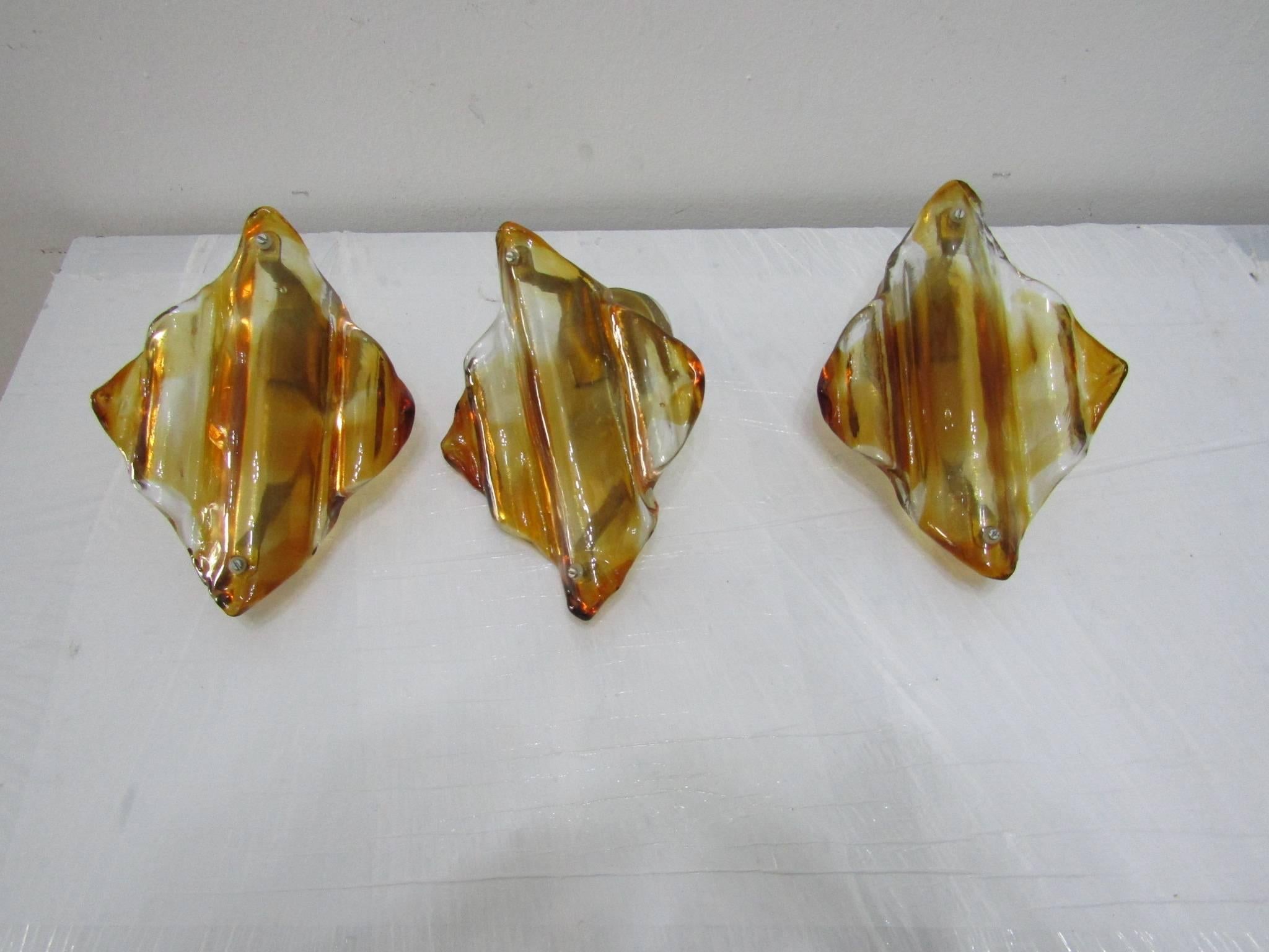 - Sculptural amber and clear glass colored wall sconce from Mazzega
- Very thick Murano glass mounted on a metal base.