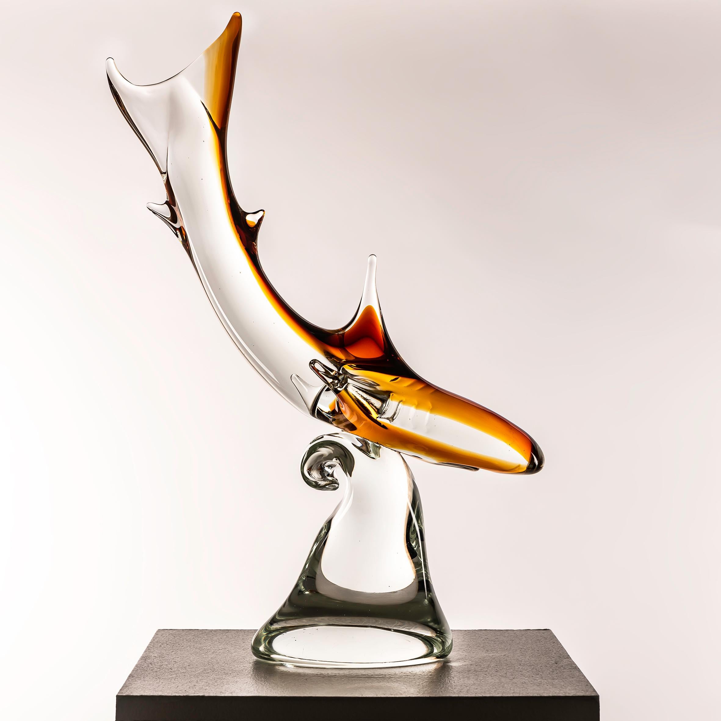 This Murano Glass Shark Sculpture from the 1960s, crafted with vibrant orange and clear glass, offers a compelling blend of artistic mastery and aesthetic appeal. Renowned for its centuries-old tradition of glassmaking excellence, Murano artisans