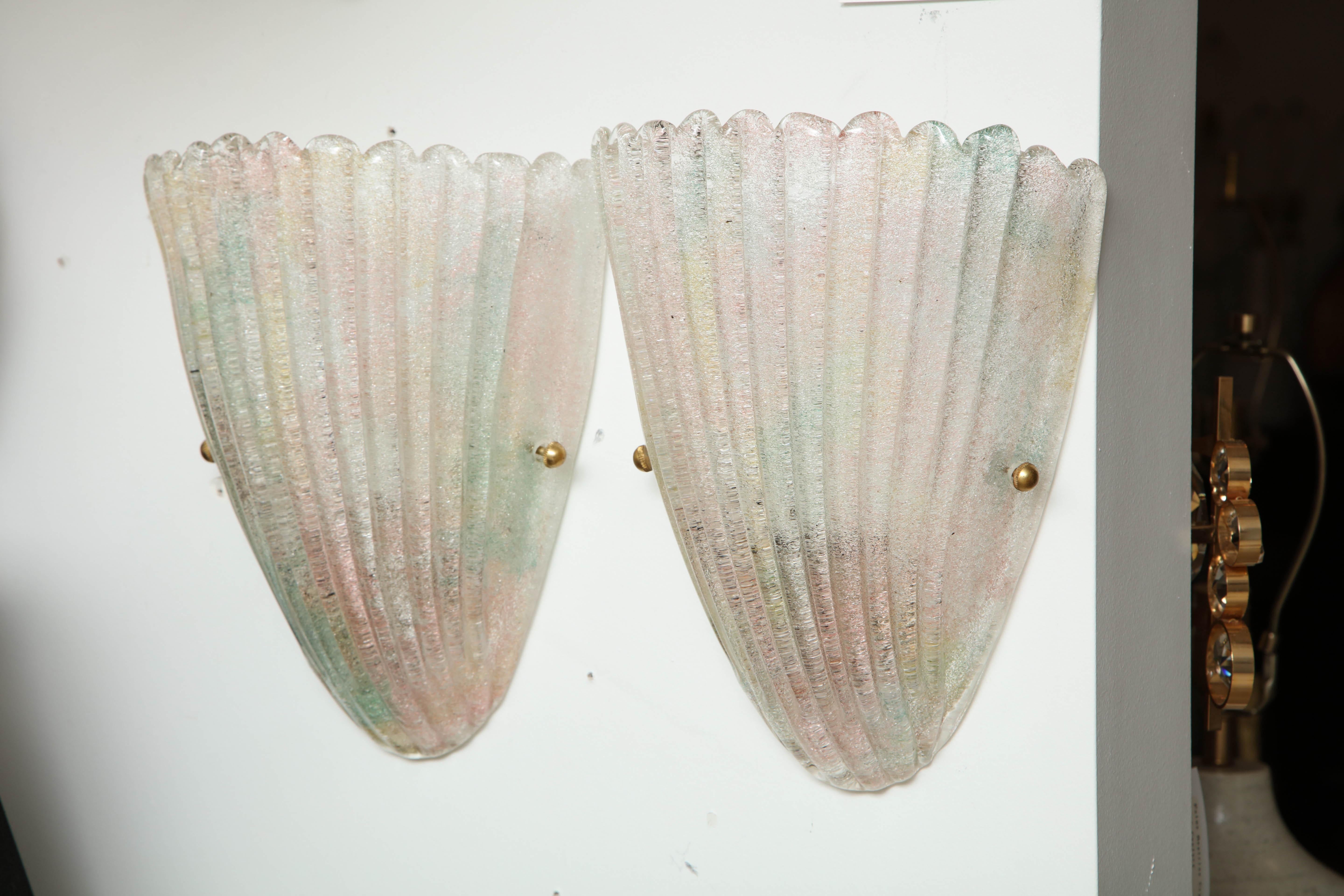 Murano glass stylized shell sconces with light undertones of blue, yellow, and pink glass, brass finials. Each sconce utilizes two candelabra type bulbs. Rewired for use in the USA.

Currently two pair are available, 2800 per pair.