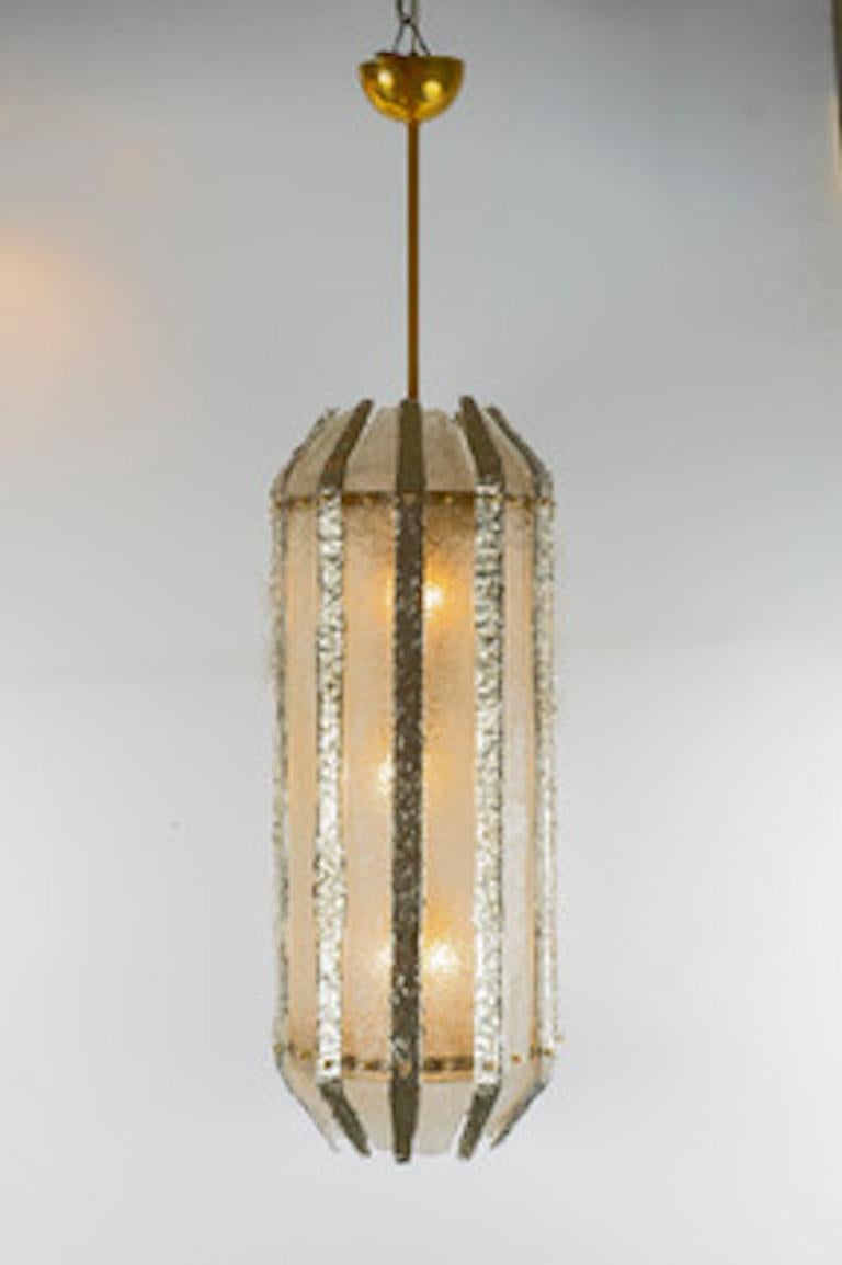 Hand blown tall glass lantern from the infamous Italian island of Murano. This contemporary fixture features highly textured glass, 11 clear and 11 silvered, with a clear glass diffuser at bottom. Overall height with canopy at 56