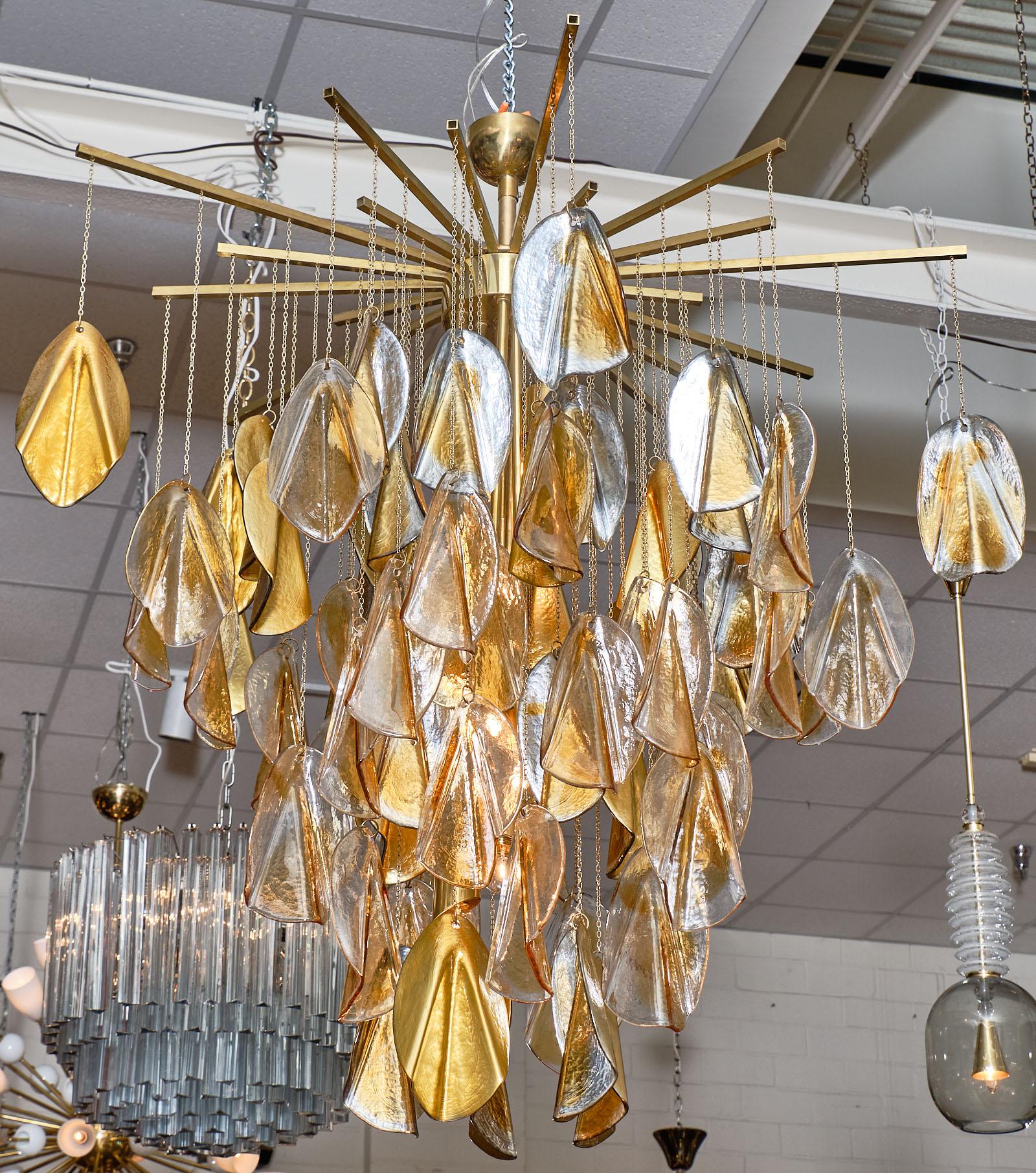 Murano glass chandelier in excellent condition. The brass structure holds 75 hand-blown glass elements - 35 with mirrored and amber glass; and 40 with clear and amber glass. This striking fixture catches the light in such lovely ways. It has been