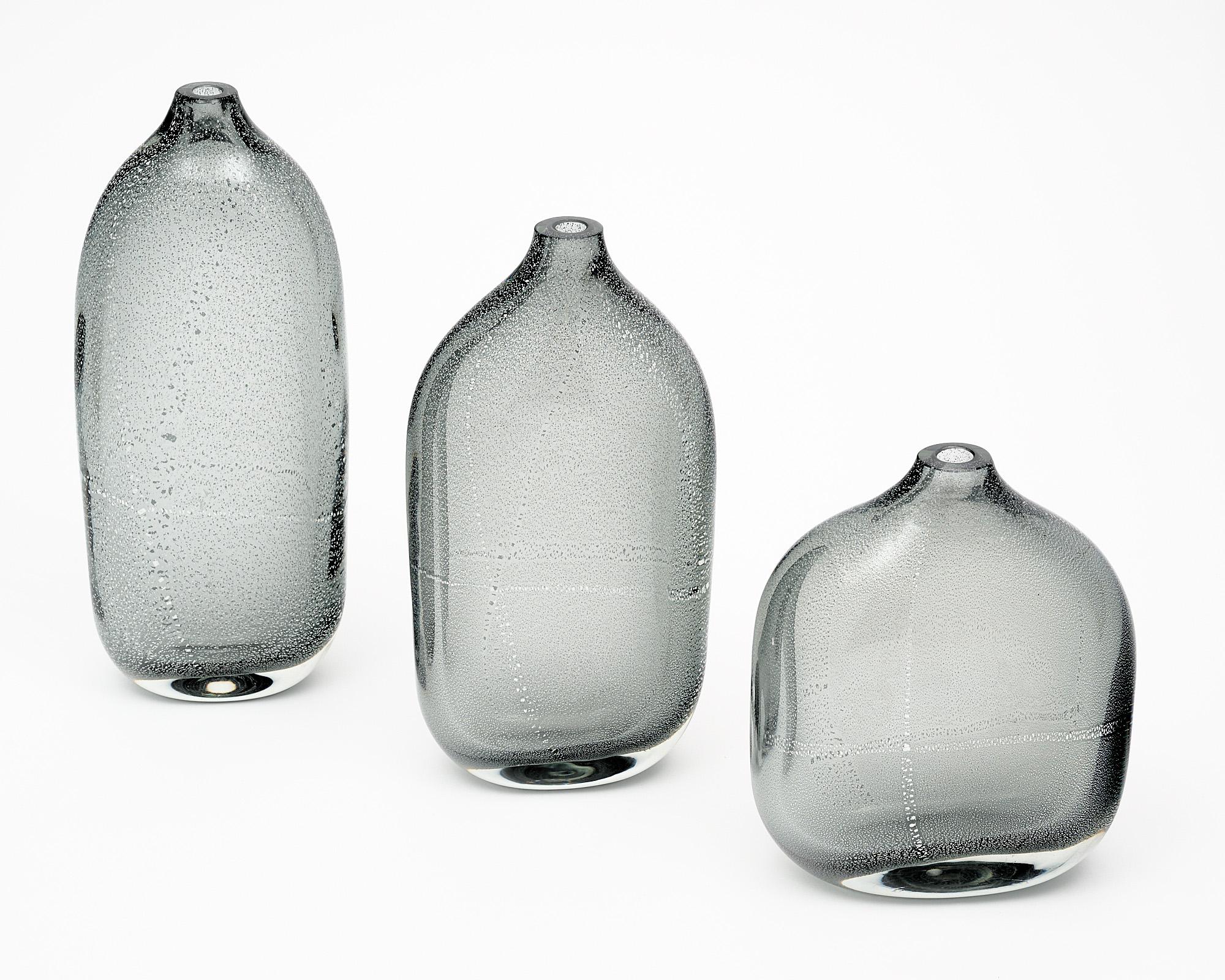 Set of three vases or bottles of hand-blown Murano glass. Each piece is crafted using the avventurina technique where silver leaf is fused within the glass during the glass blowing process. The price is for the set of three. They are signed by glass