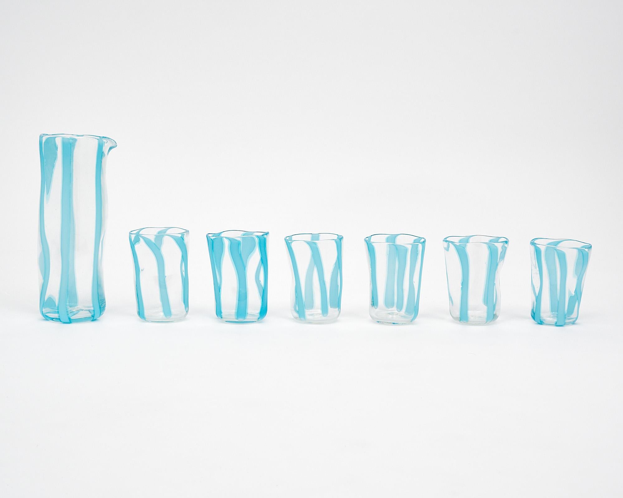 Set aus sechs Murano-Glasbechern und passender Karaffe. Dieses Set wird vollständig aus mundgeblasenem Glas auf der Insel Murano bei Venedig hergestellt. Sie haben ein transparentes Glas mit himmelblauen Streifen. Wir lieben die organischen Formen