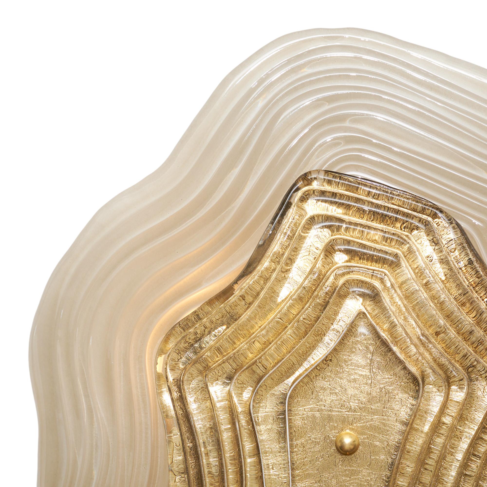 Pair of wall sconces from Murano island outside of Venice, Italy. This pair has two pieces of hand-blown glass layered and held in place by brass finials on a brass structure. The back piece of glass is smoked. The top piece of glass is gold leafed.