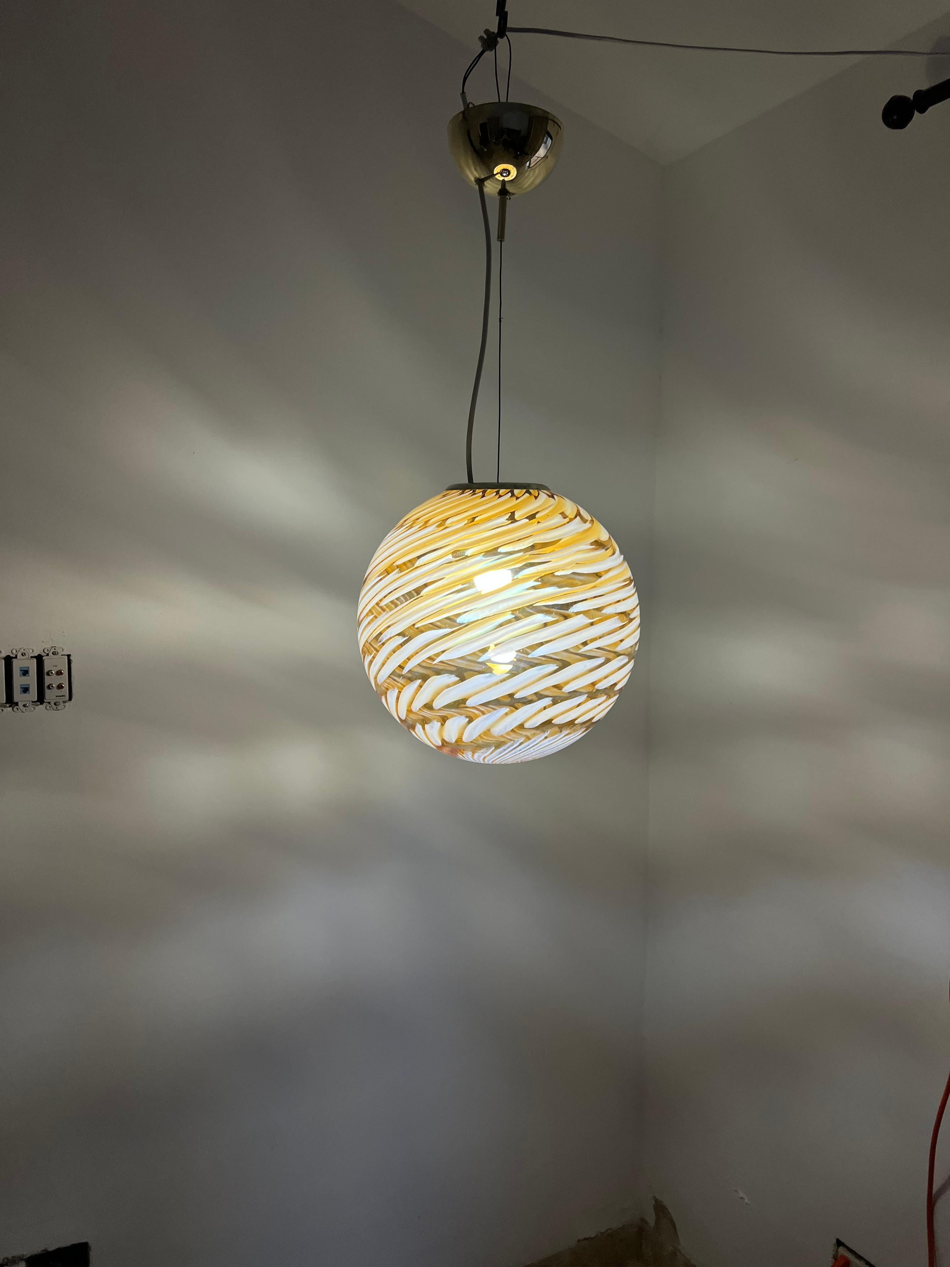 Mid-Century Modern sphere in Murano glass attributed to Venini.
The globe is made in clear, white, yellow and orange glass tones, catching the light differently according to the bulb used as shown in out photos.
Made in Murano Italy circa