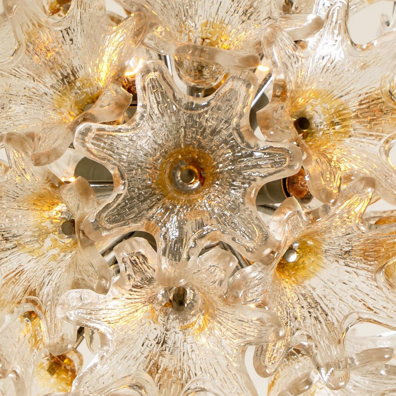 Elegante lampada di Murano di Paolo Venini per VeArt, Italia, anni Sessanta. L'apparecchio cromato con fiori a forma di stella in oro/ambra e trasparenti. La luce si illumina magnificamente su pareti e soffitti.

La lunghezza della catena può essere