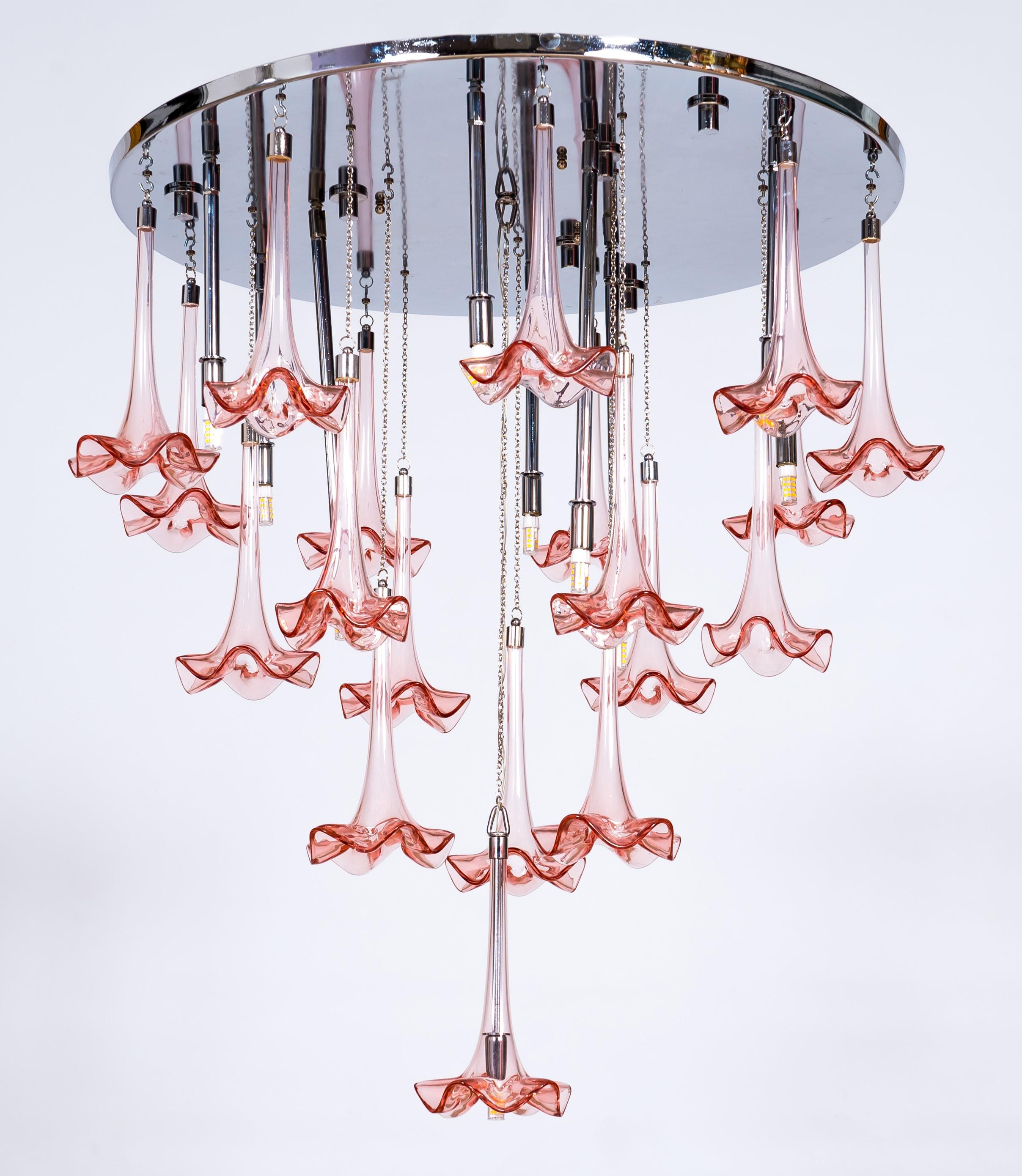 Moderne LED-Murano-Glashalterung mit rosa Blumen von Giovanni Dalla Fina
Schöner und stilisierter Kronleuchter mit einer Kaskade von rosa Blumen, die von einem runden, verchromten, glänzenden Rahmen hängen, der das Licht reflektiert. Die Ränder der