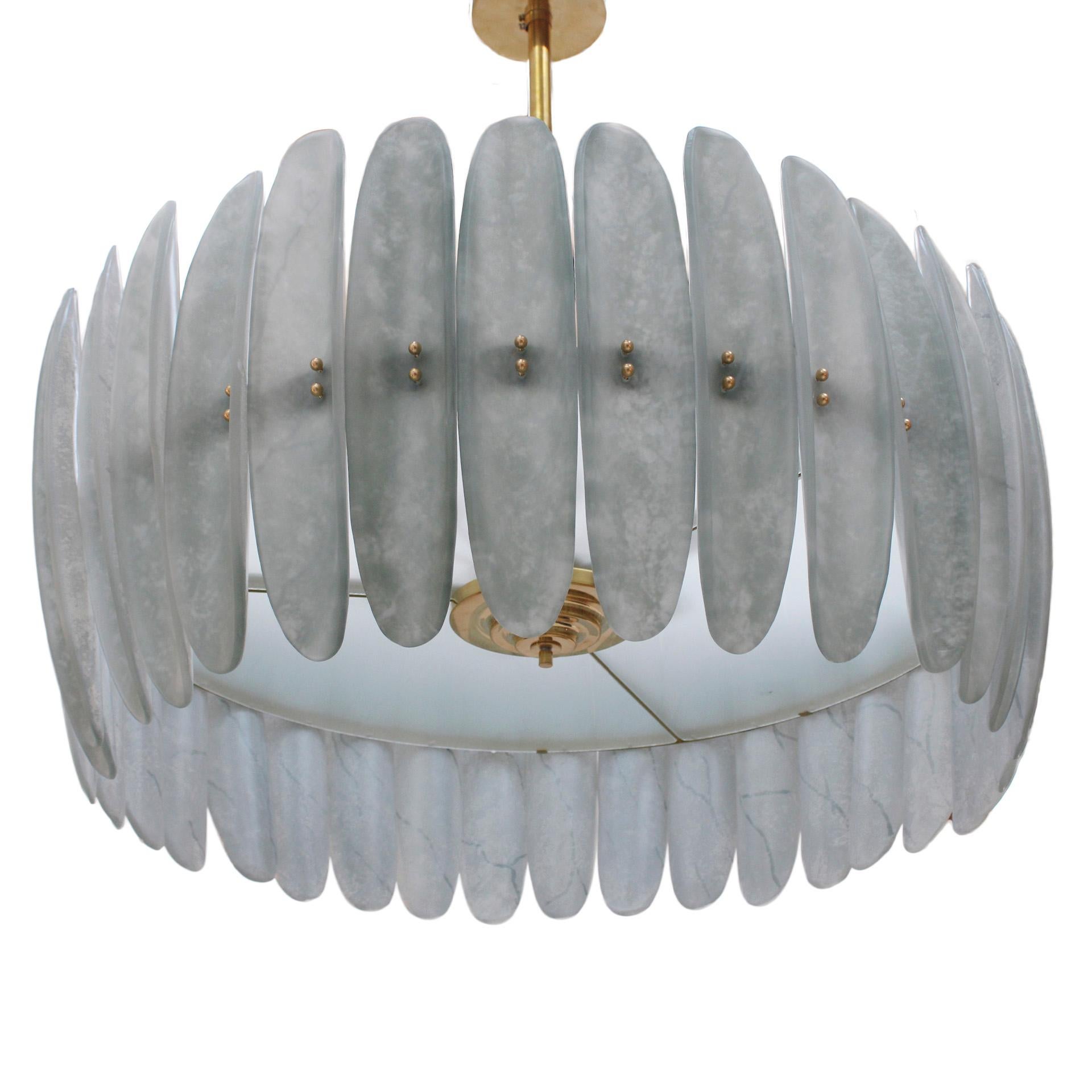 Suspension lamp with a circular structure made of brass and metal, decorated with pieces made of Murano glass around the perimeter. Current production from Murano, Italy.

This Murano chandelier showcases exquisite artistry in glass and brass. It