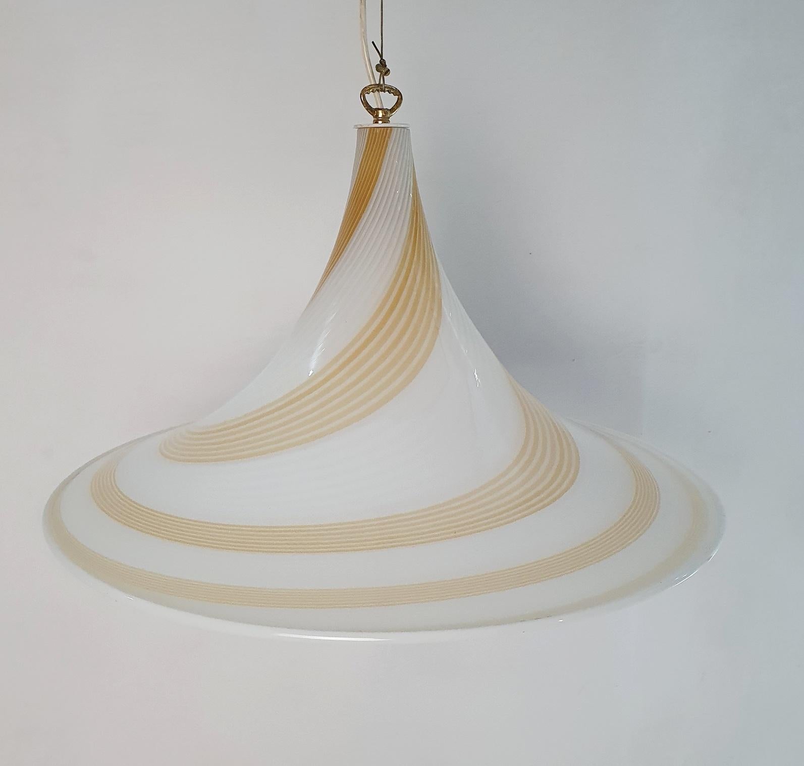 Preciosa lámpara de techo grande de cristal de Murano hecha a mano con un diseño giratorio en color trigo/caramelo y blanco. Elegante e impactante en su sencillez. La luz brilla a través de la lámpara y crea unas sombras preciosas. Recomendamos una