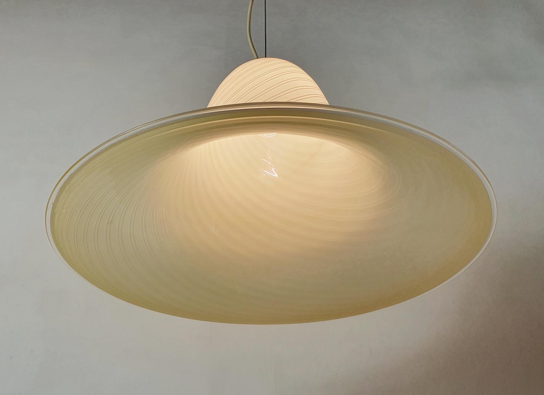 A beautiful large handmade Murano glass ceiling lamp with a swivel design in wheat/caramel and off-white. Elegant and striking in it´s simplicity. The light shines through the lamp and creates a beautiful shadows. We recommend a larger lightbulb for