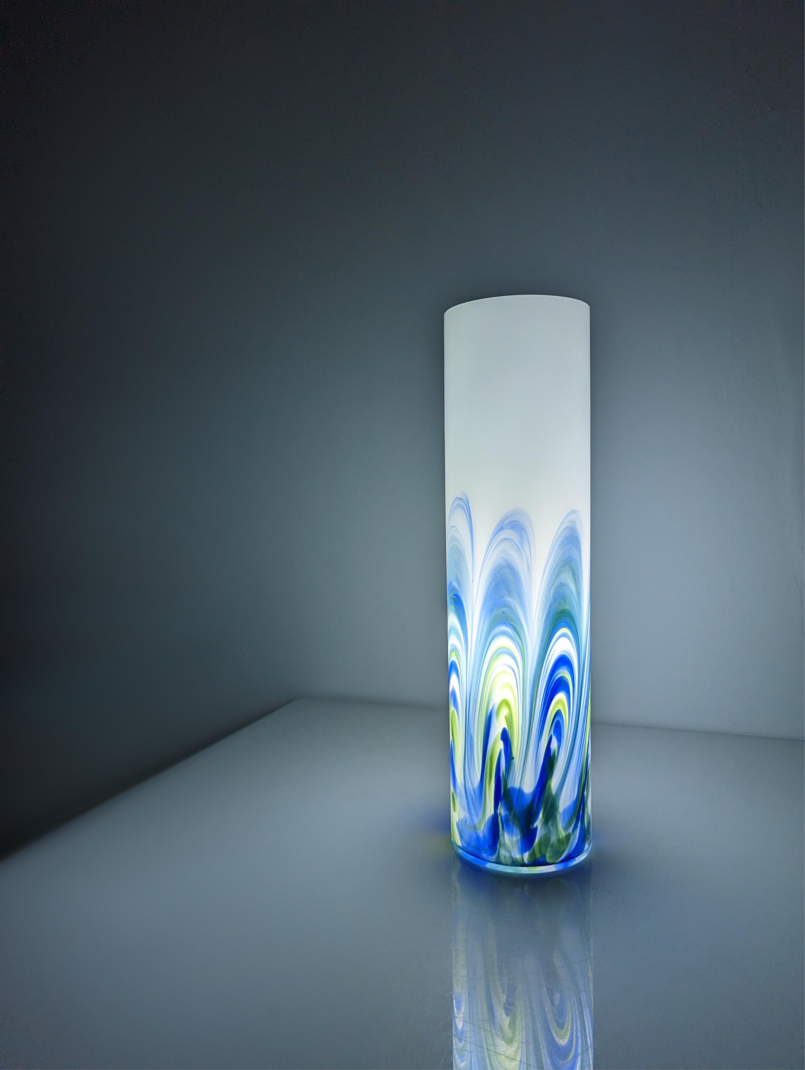 Lámpara realizada en cristal de Murano blanco con ondas de tonos azules y verdes reflejando una preciosa luz y formas.

Dimensiones: 44,5 x 12 cm.