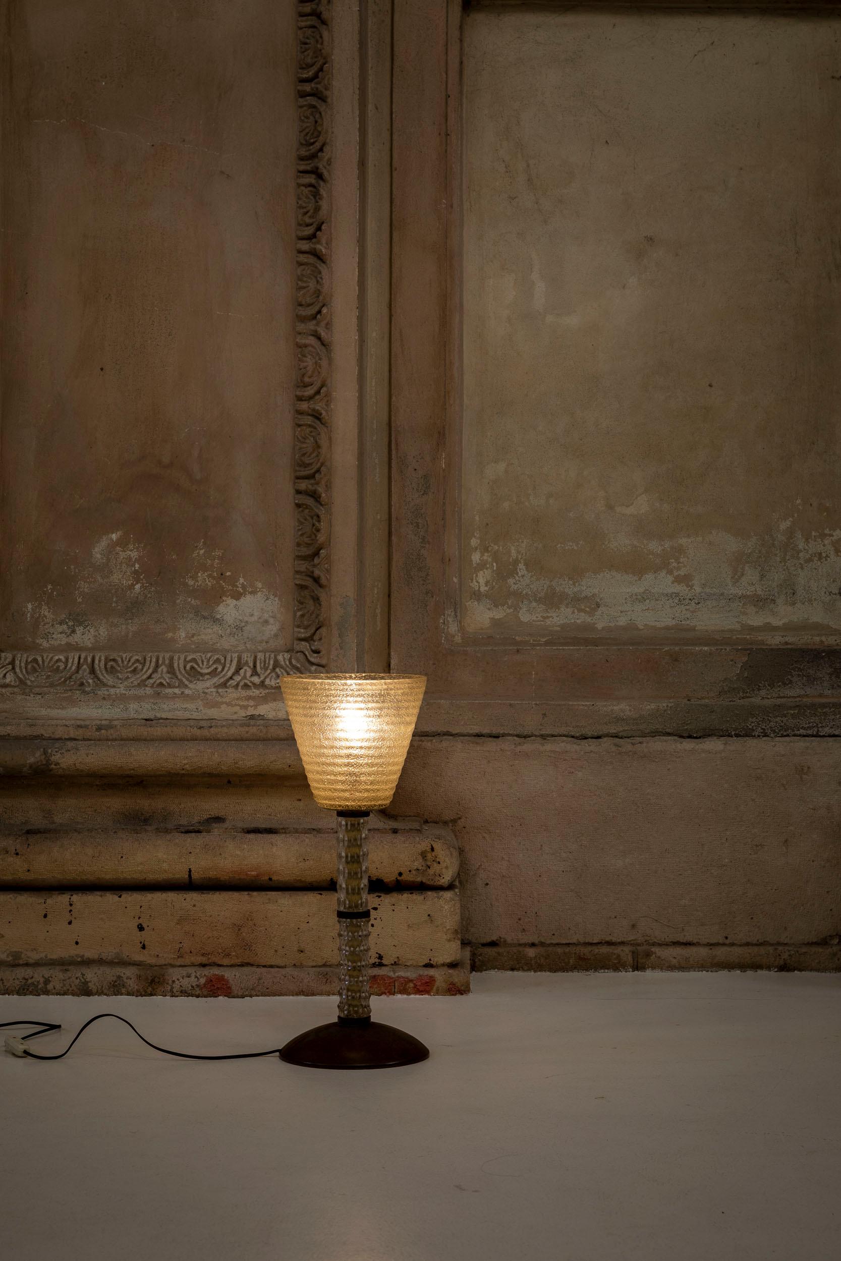 Lampe de table en verre de Murano attribuée à Seguso, Italie, 1940 environ.
Belle lampe de table composée d'un abat-jour conique en verre finement décoré, dans le ton du vert clair. La lampe présente une base circulaire en laiton et une tige en