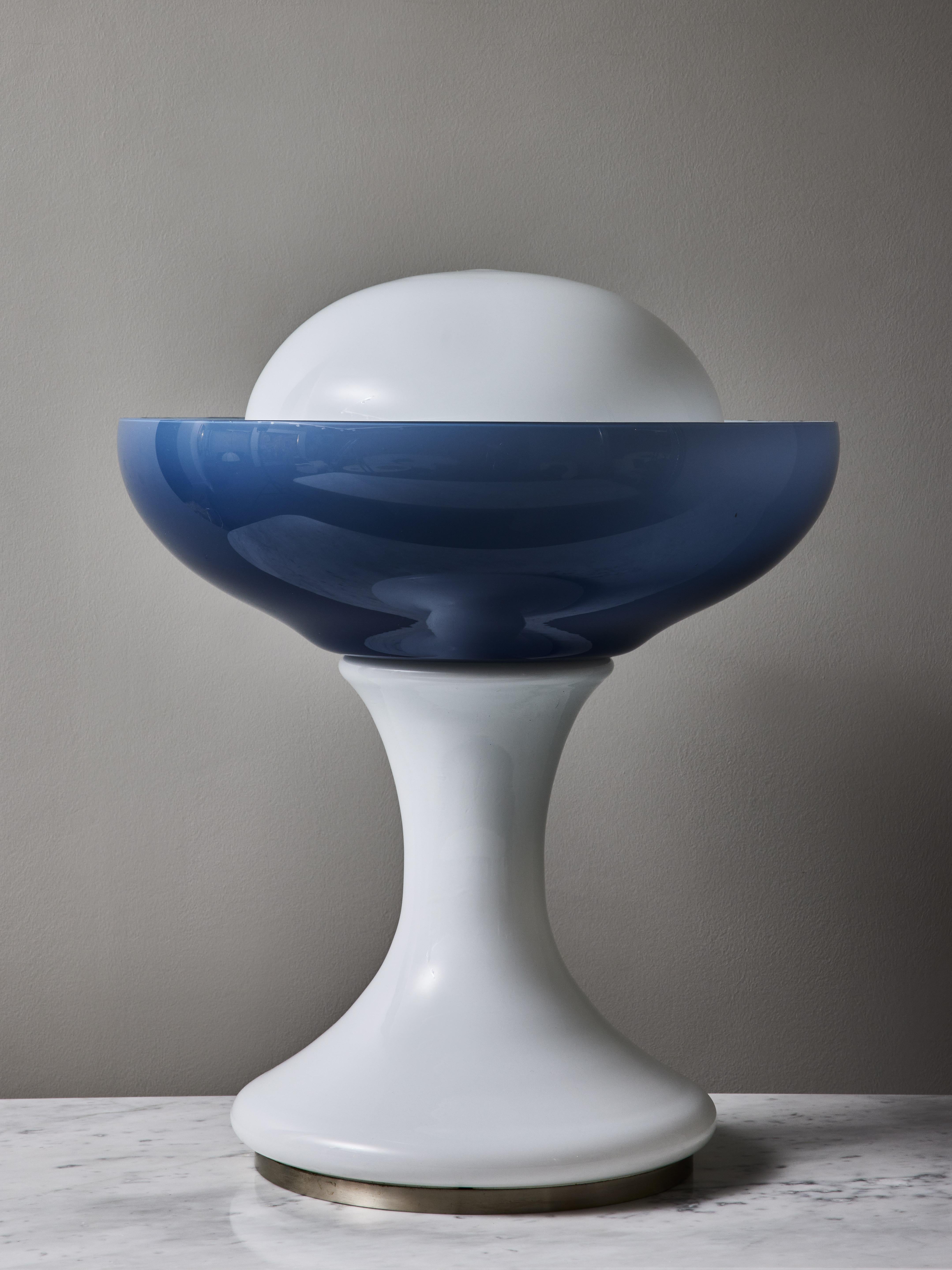 Beautiful floor lamp made of stacked opaline Murano glass. The curved shape of the body ends up with a blue cup giving a loverly hue when the piece is enlightened.
