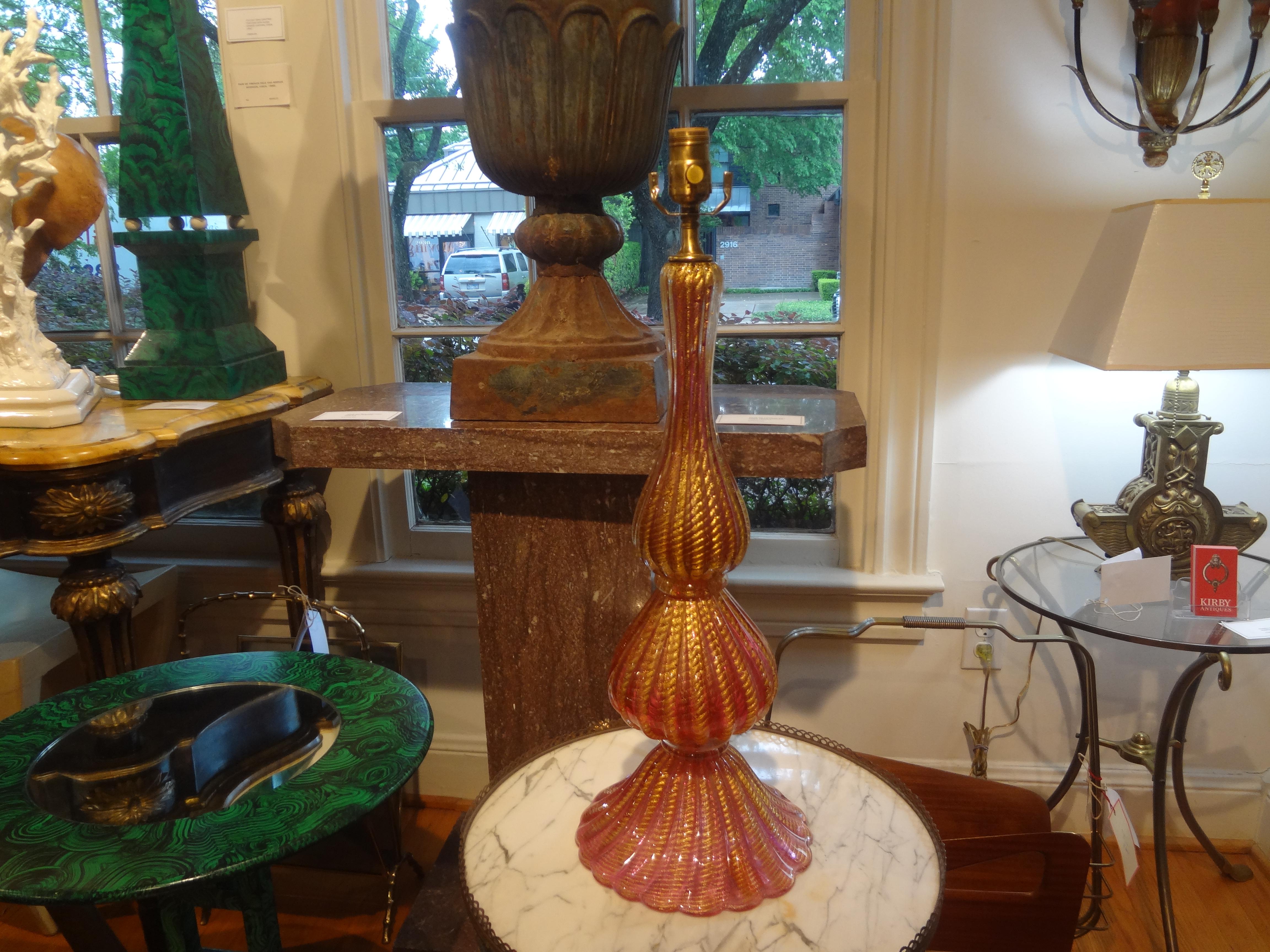 Murano glass table lamp by Seguso.
This stunning vintage tall Murano glass lamp was hand blown in a gorgeous raspberry colored glass with loads of infused gold flecks. Our shapely Murano lamp has been newly wired with a new socket for the U.S.