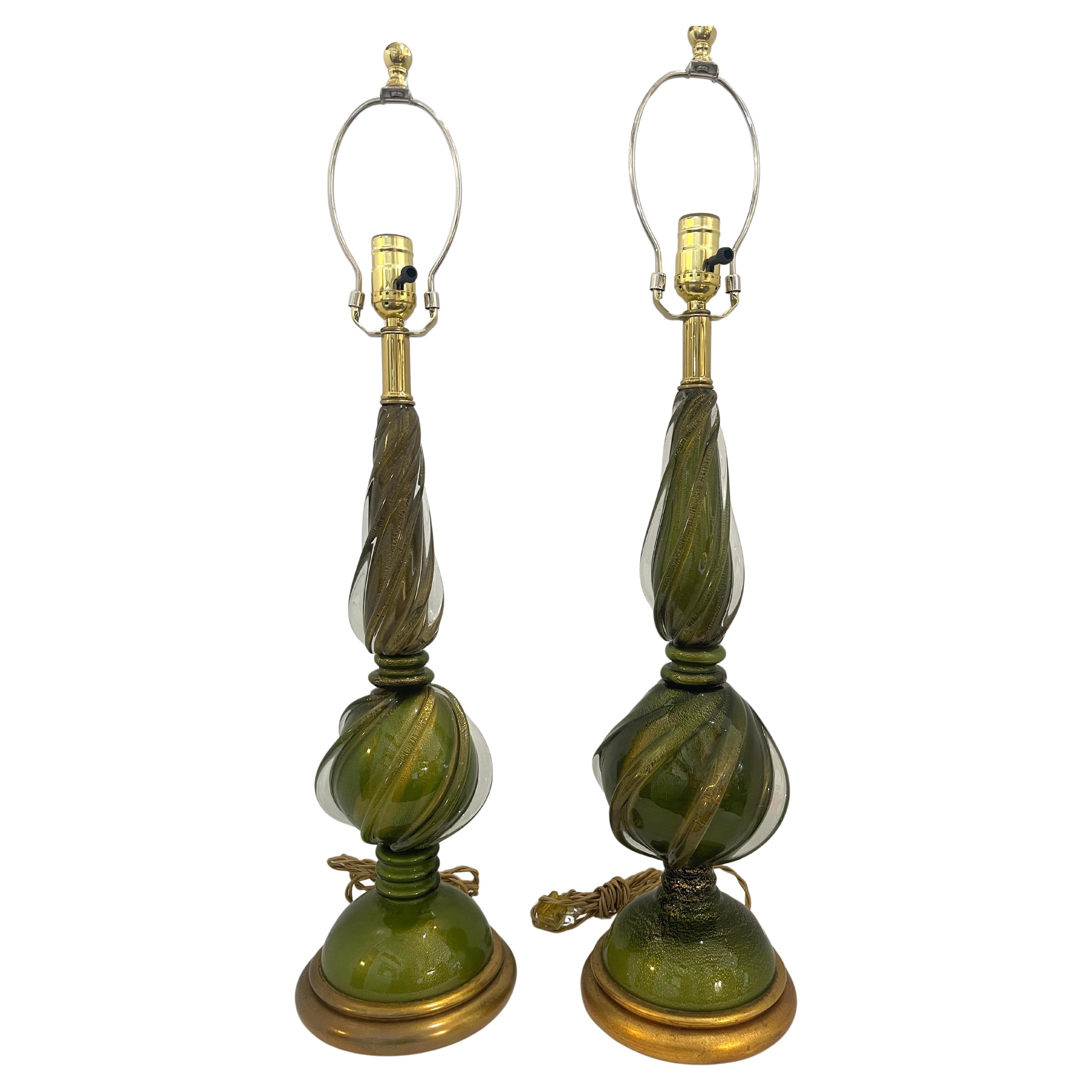 Just in this wonderful pair of Murano Glass Table Lamps in Green & Gold Flecks on Gilt Wood Base,.
This pair has a mouth blown Twisted bulbous bottom and a twisted candle like top.
The color is Green with Gold flecks through out. these lamps stand