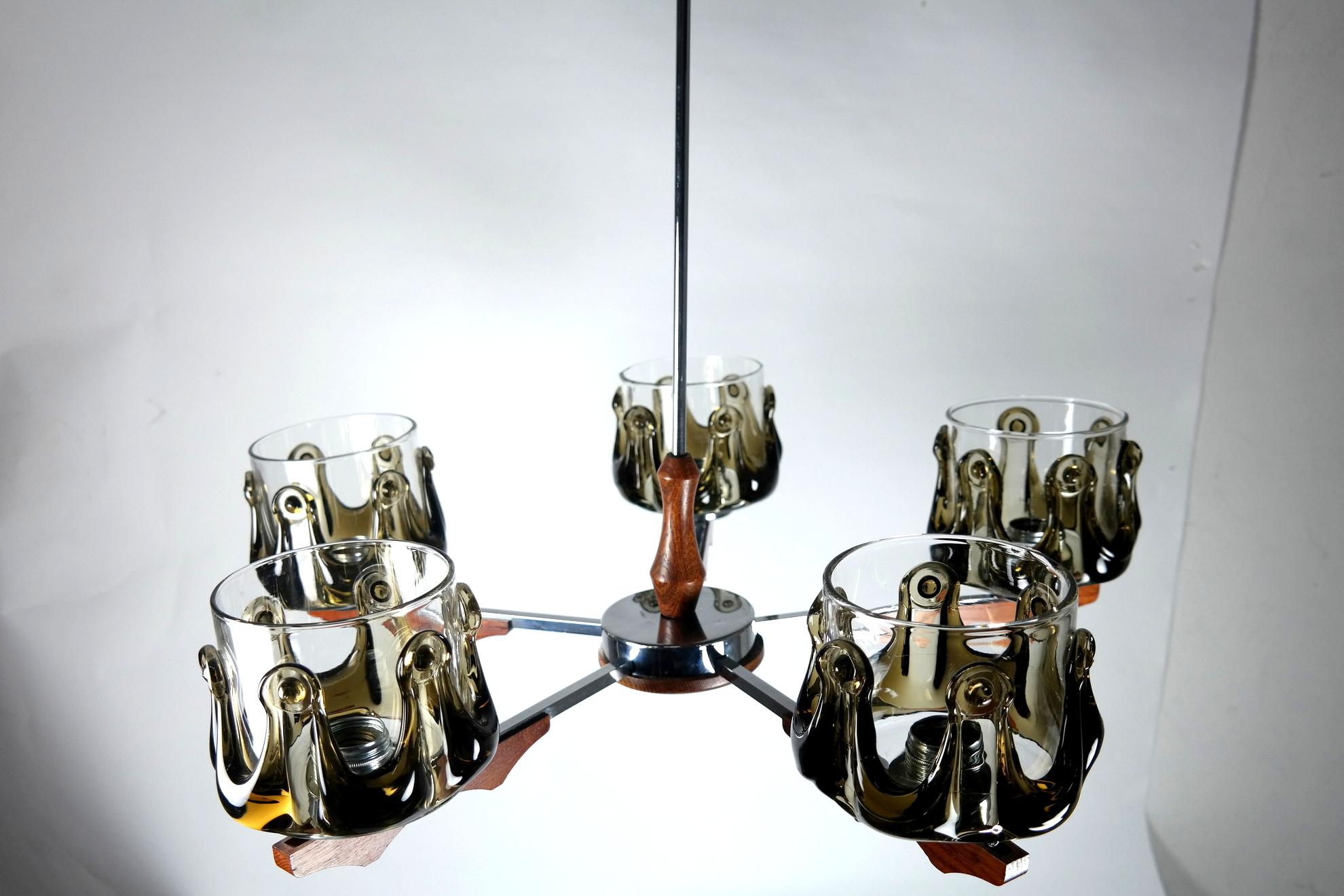 This Murano glass, teak, and chrome chandelier is an extraordinary design made in the 1970s- it's in great condition, working order on 220V’s.

 
