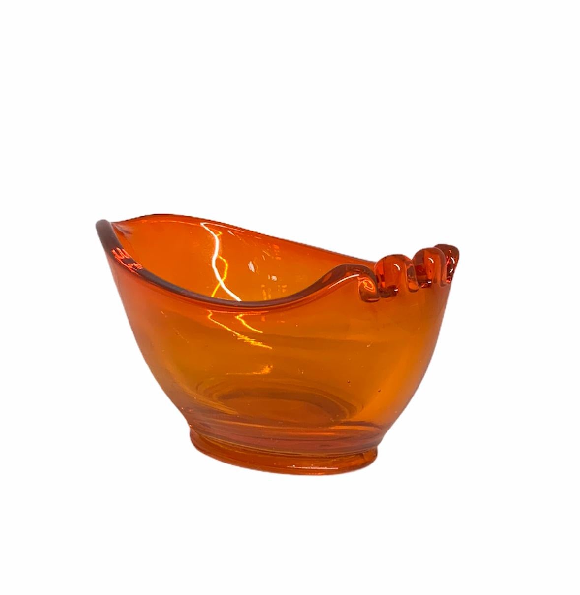 This is a tangerine color scoop shaped bowl ashtray for three cigarettes.