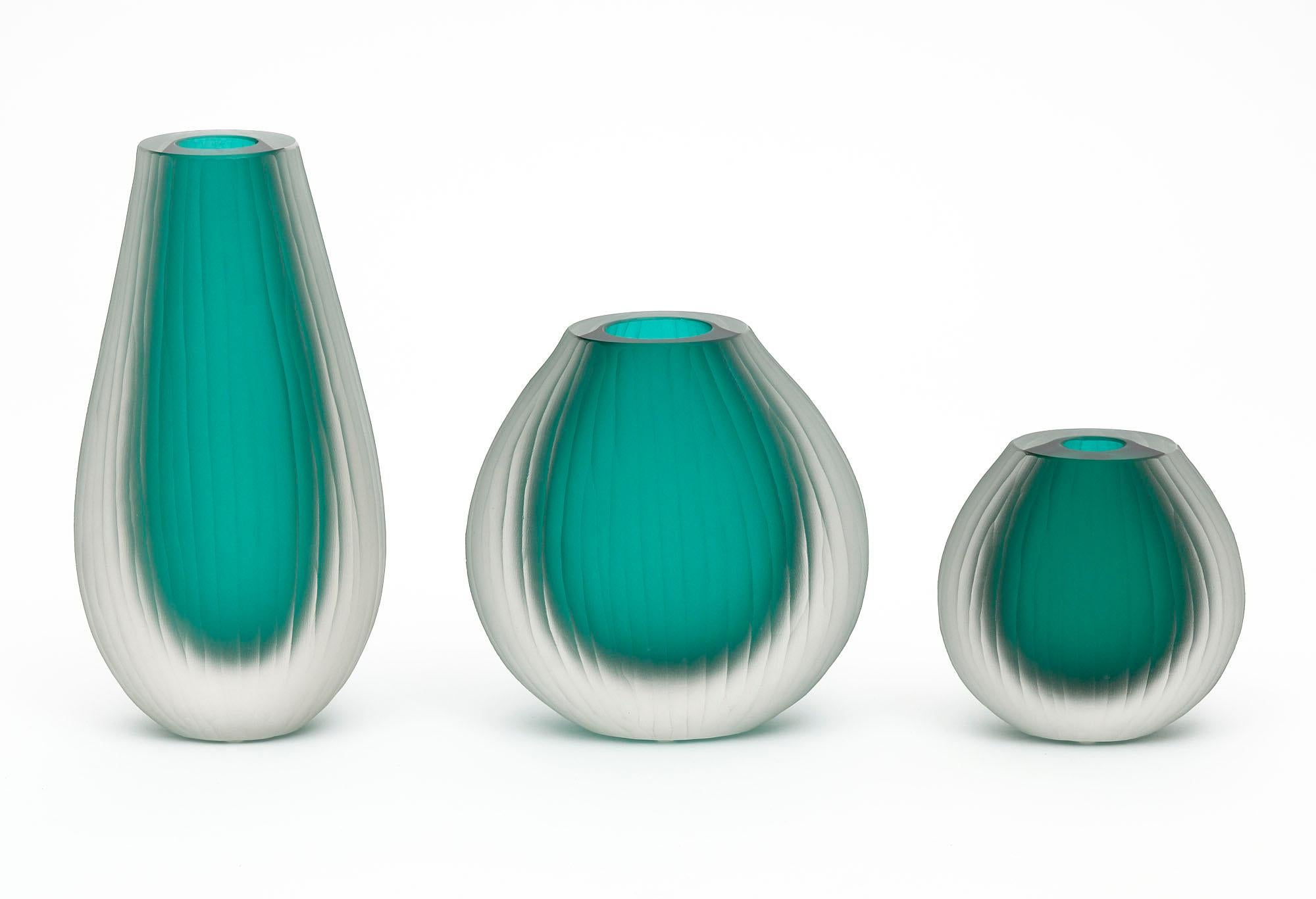 Set of three Murano glass vases in the manner of Tobia Scarpa. The set has been made using the “battuto” or hammered technique. They are in a beautiful emerald tone. The measurements listed are for the tallest vase. The measurements for all three