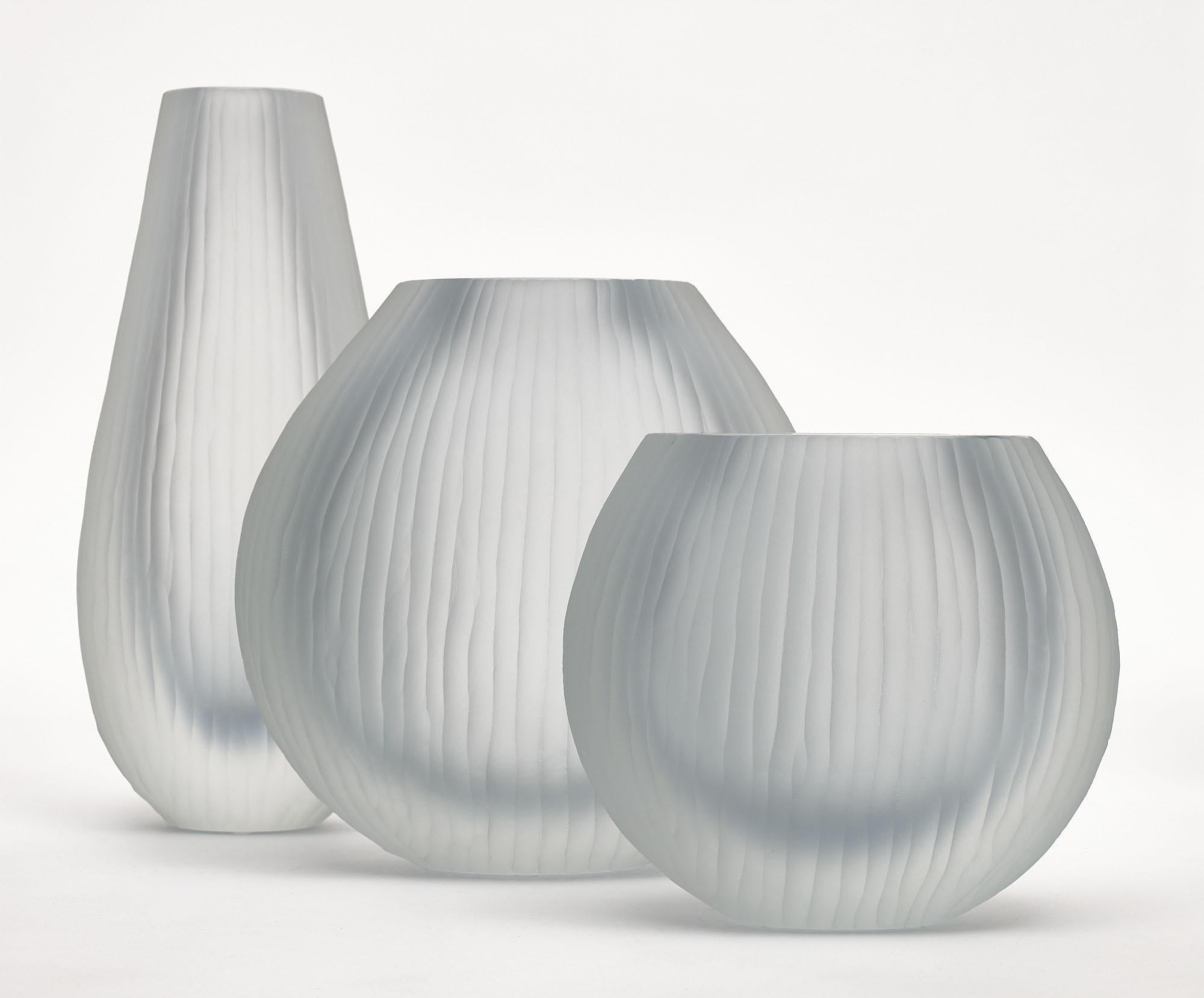 Set of three Murano glass vases in the manner of Tobia Scarpa. The set has been made using the “battuto” or hammered technique. They are in a beautiful light blue-gray tone. The measurements listed are for the tallest vase. The measurements for all
