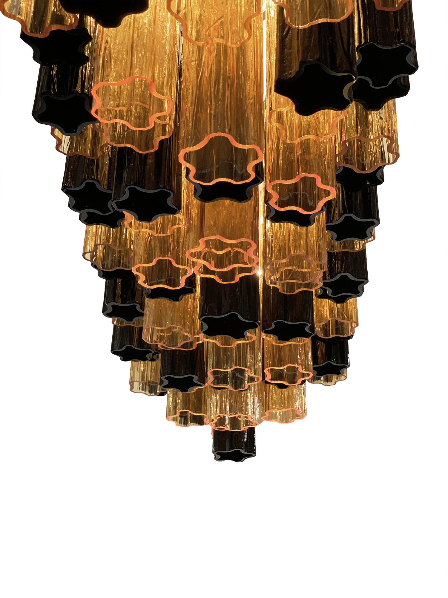 Murano glass tronchi chandelier by Alberto Dona. This piece, from Italy, combines a hand blown tronchi glass components in both black and amber tones. It has been newly wired to fit US standards and requires ten candelabra base bulbs. The current