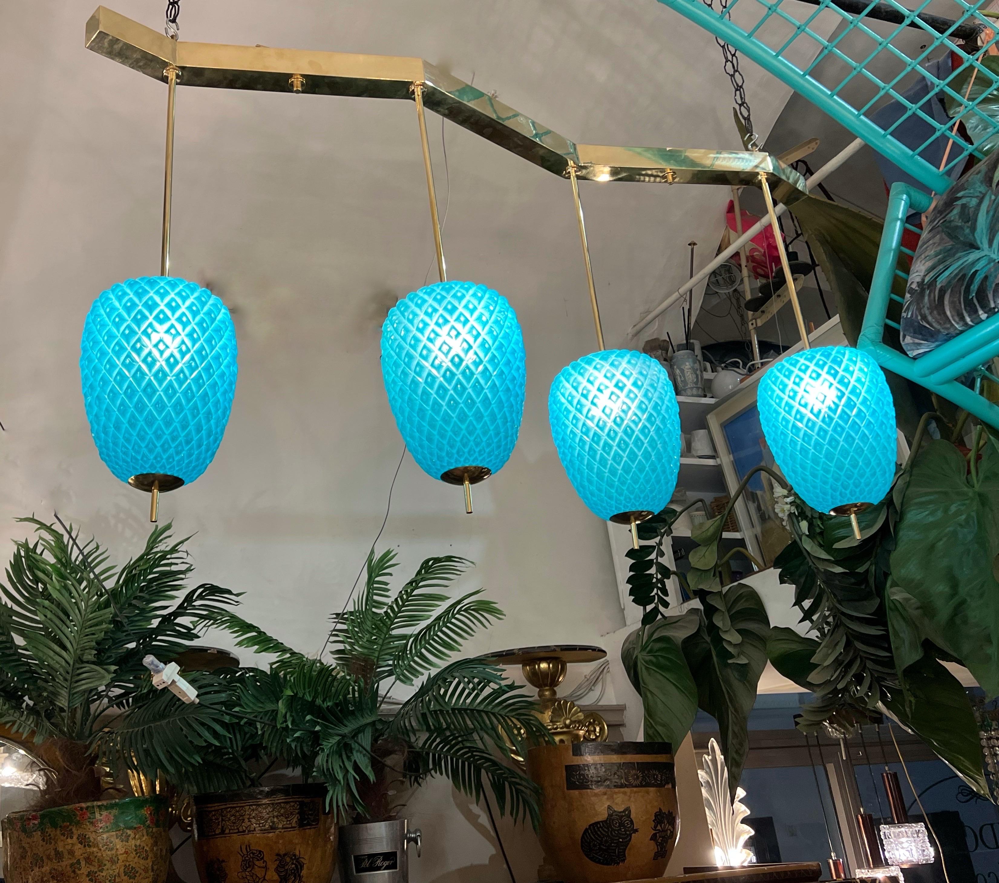 Pineapple shaped Turquoise Murano glass pendant chandelier with 4 lights and Brass Structure. Perfect for placing on a dining table. It can be fixed directly on the ceiling of the drop down as needed.