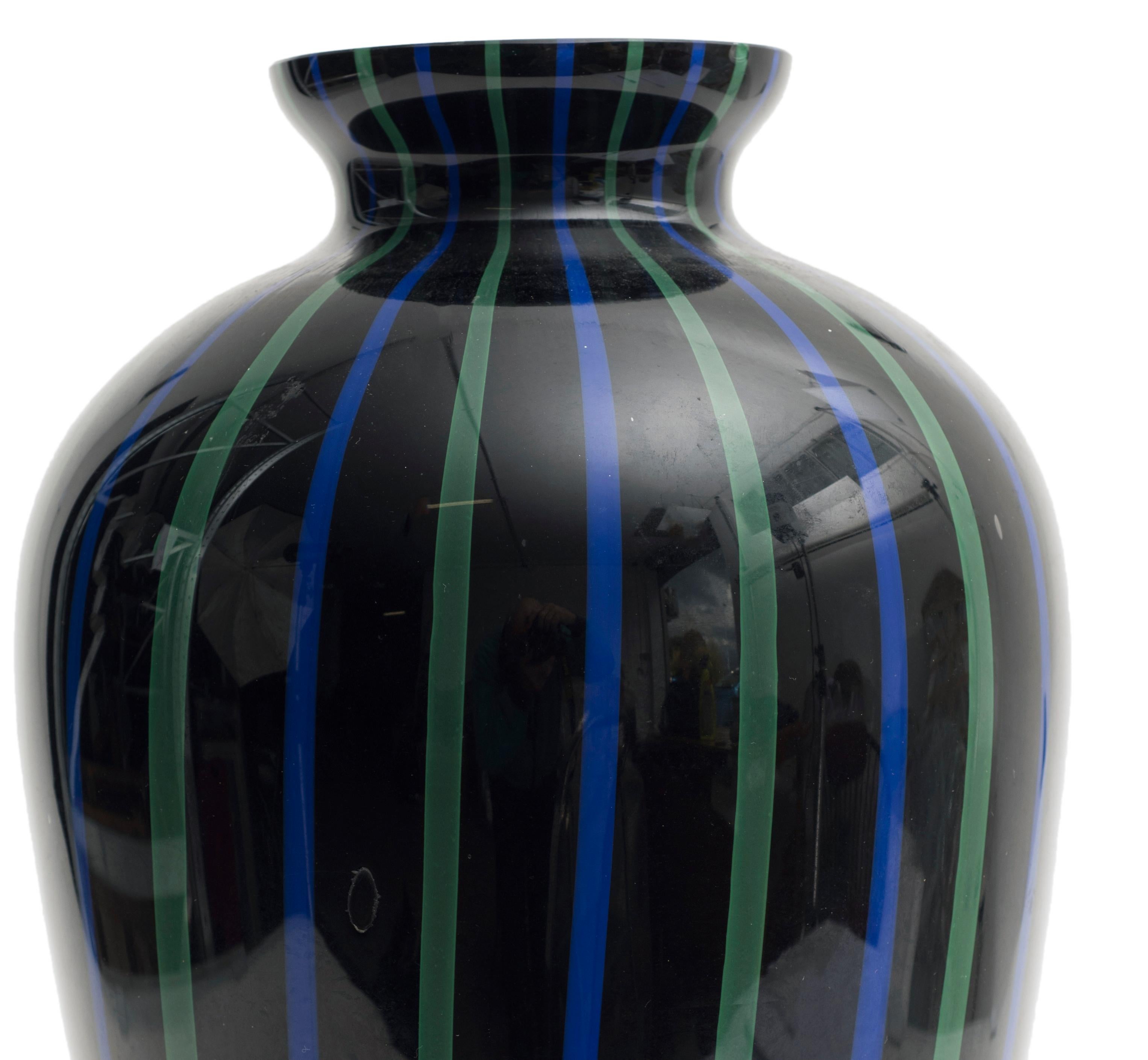 Magnifique vase en verre de Murano.
Le vase est noir et décoré de lignes verticales vertes et bleues.
Créé dans les années 1970.
Très bonnes conditions.