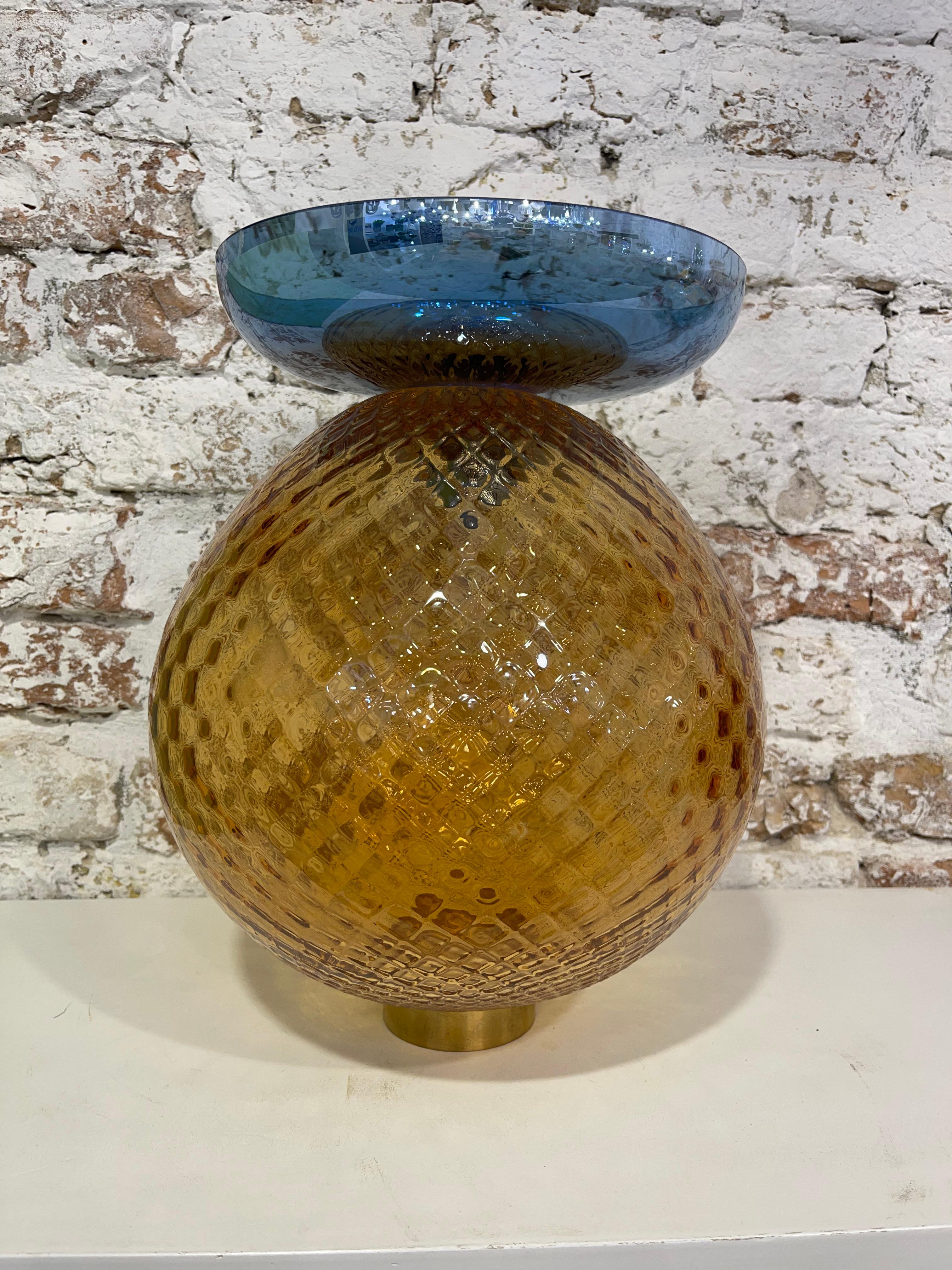 This colorful vase is a unique piece in both its form and colors. For this technique, the master glassmaker uses a special metal mold which has small pyramid-shaped tips with a square base all along the interior surface of its circumference. 
During