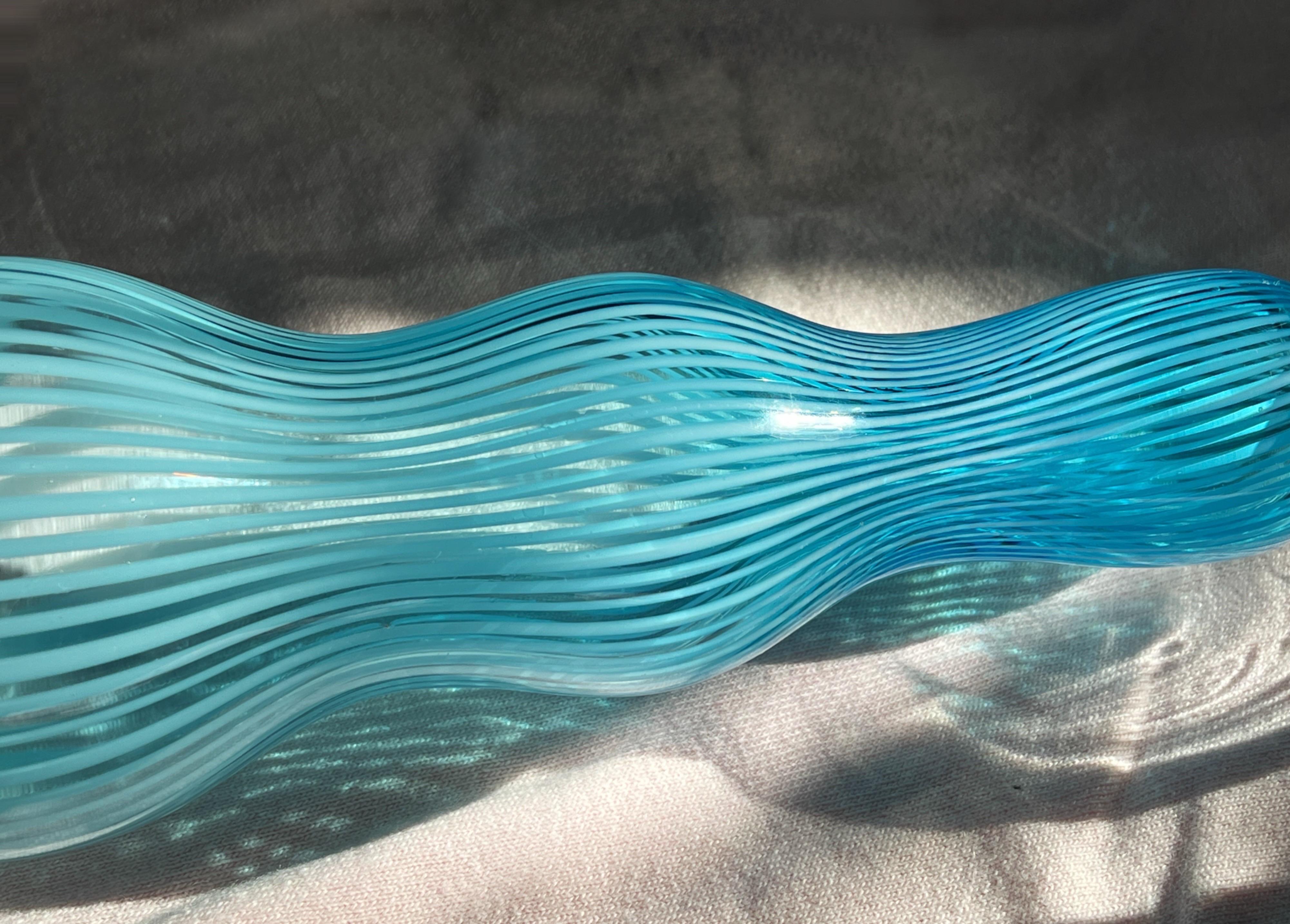 Vaso di vetro a righe unico ed elegante, trasparente e blu ghiaccio, abilmente realizzato da Federico Scarpa!
Proveniente da Murano, in Italia, questo squisito vaso presenta una straordinaria miscela di vetro blu ghiaccio e vetro trasparente,